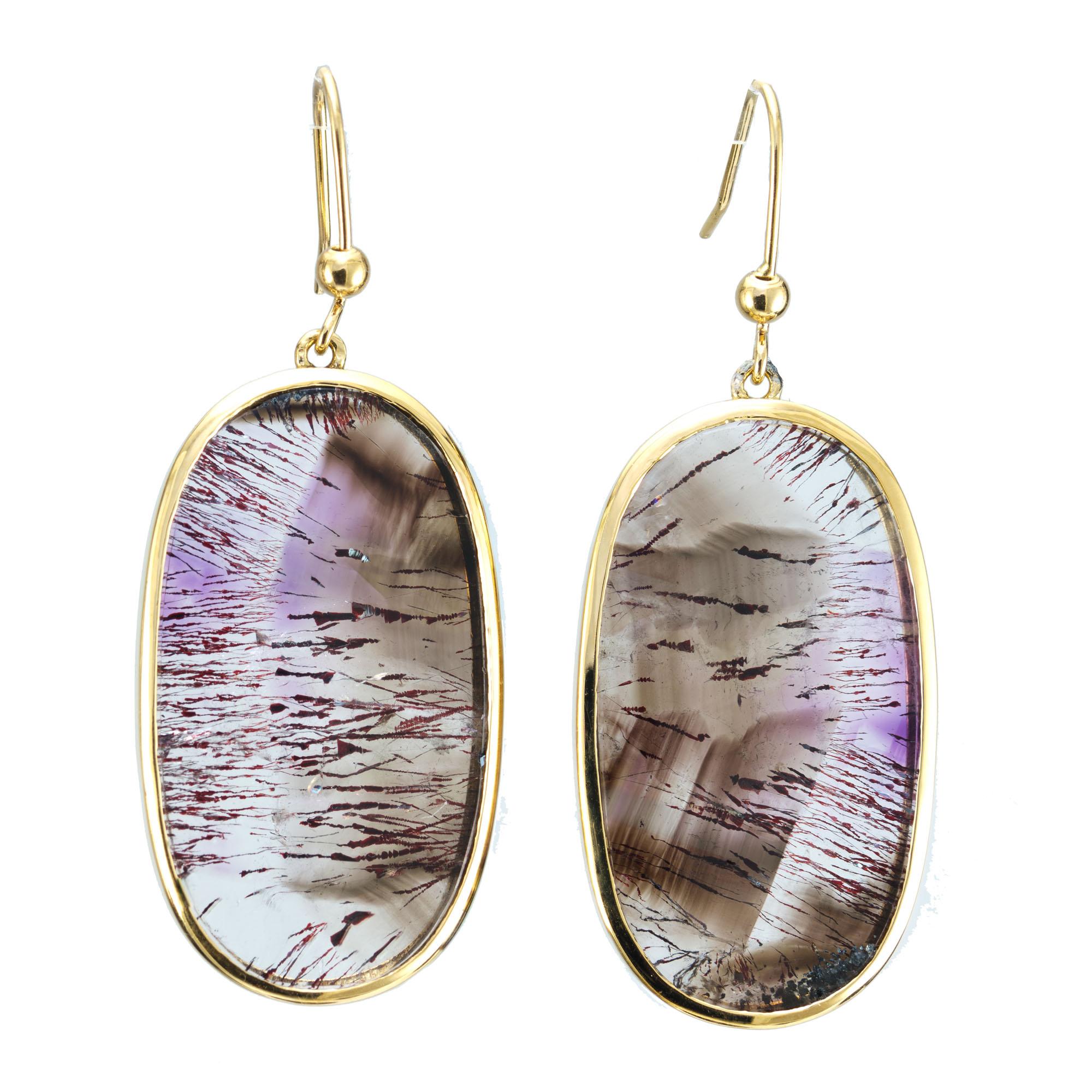 Rutilated amethyst quartz dangle earrings. 2 oval quartz in 14k yellow gold settings that were handmade in the Peter Suchy Workshop. Natural clear Quartz with Amethyst Rutile and other natural inclusions. 

Clean Quartz with natural Amethyst Rutile