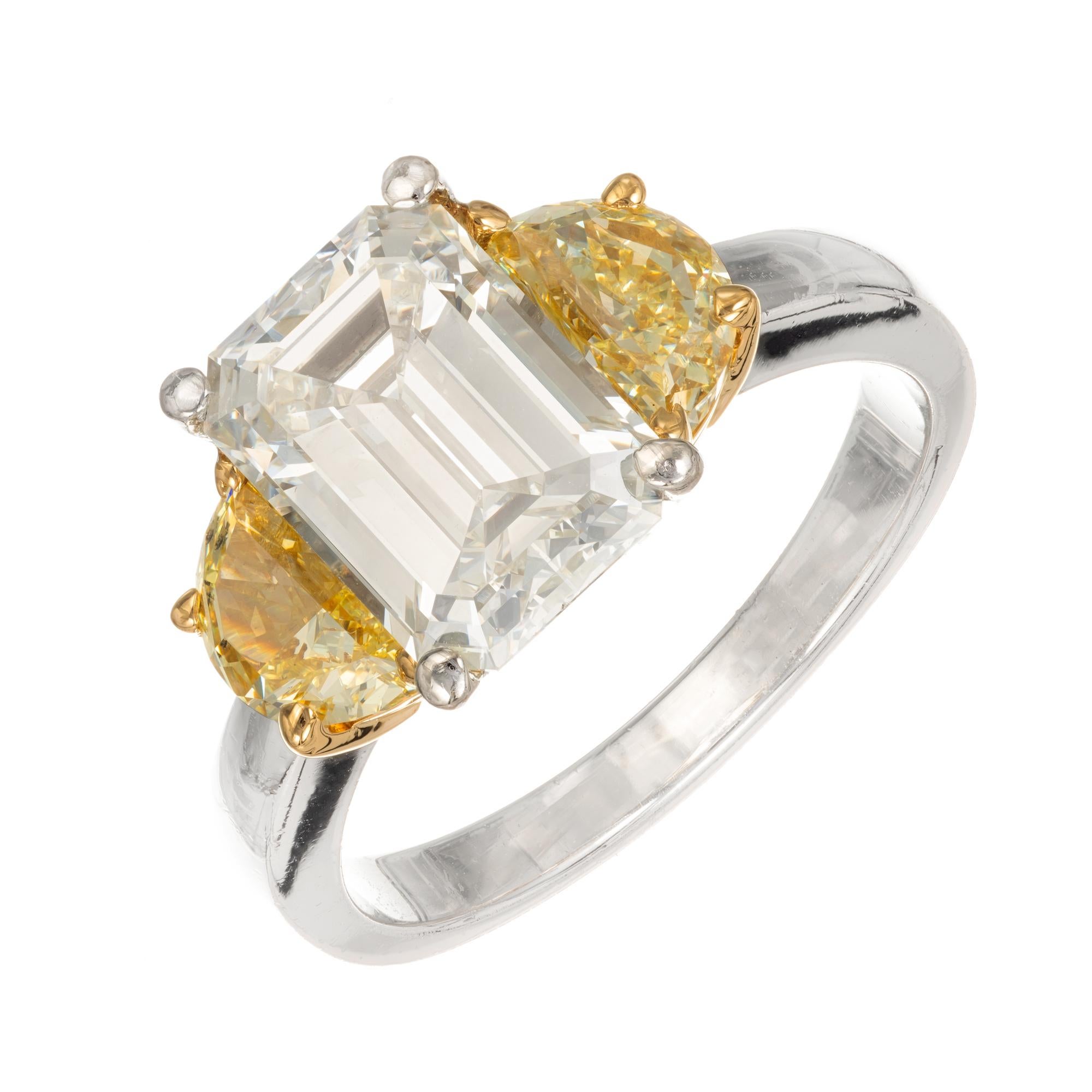 Emerald step cut diamond and half moon diamond three-stone engagement ring. GIA Certified center stone with two half-moon fancy yellow diamonds. Platinum setting with 18k yellow gold under the side diamonds. Created in the Peter Suchy Workshop.

1