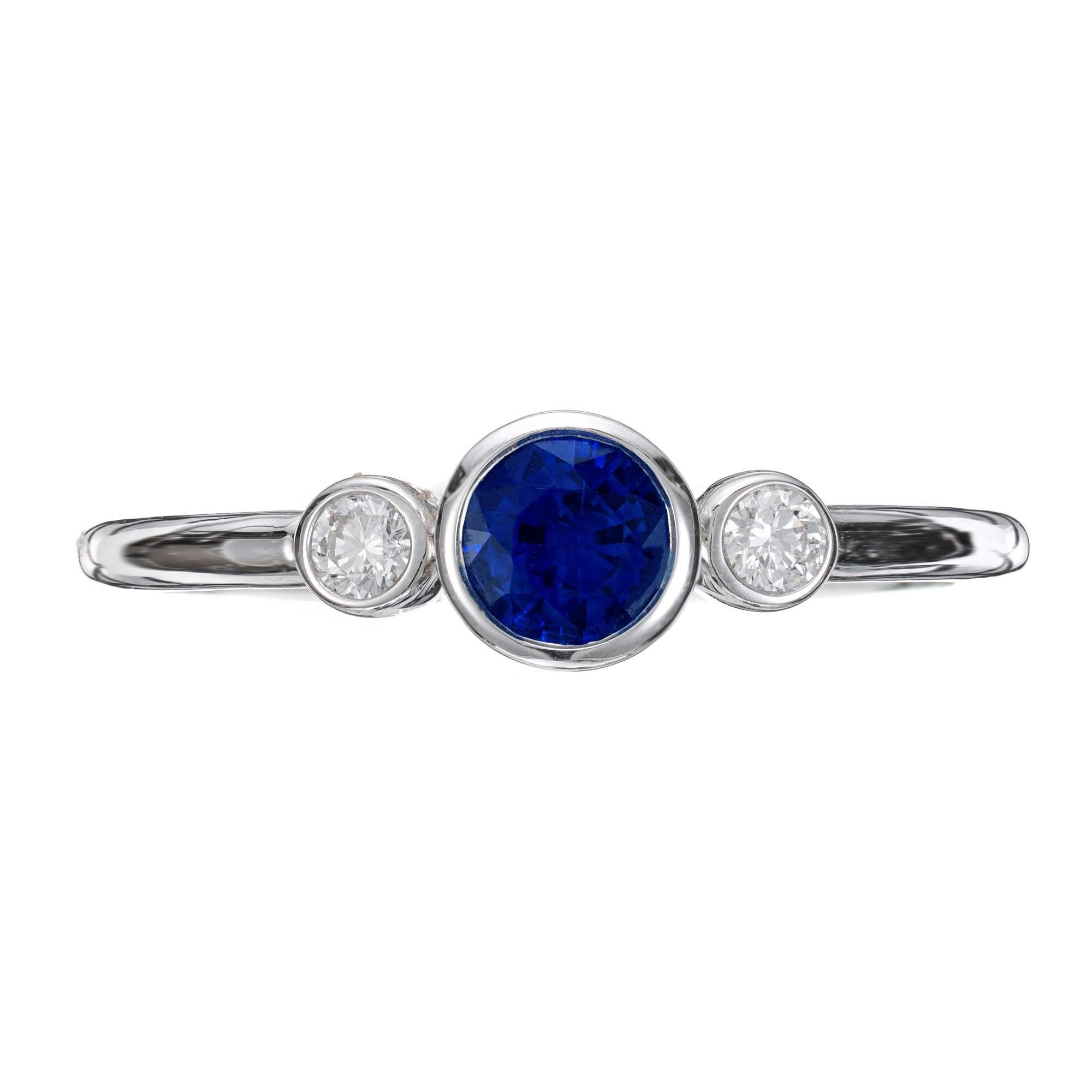 A classic style ring with a .45 carat round sapphire center accompanied by two side diamonds equaling about .10 carats total set in an 18k white gold ring setting developed by Peter Suchy. This exquisite piece beautifully marries the deep blue