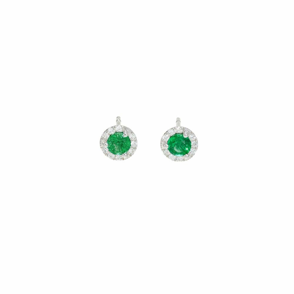 Emerald and diamond earrings. 2 round cut rich green emeralds set in three prong 18k white gold settings. Each emerald has a halo of round diamonds around them. Designed and crafted in the Peter Suchy Workshop for day time or evening wear. 

2 round