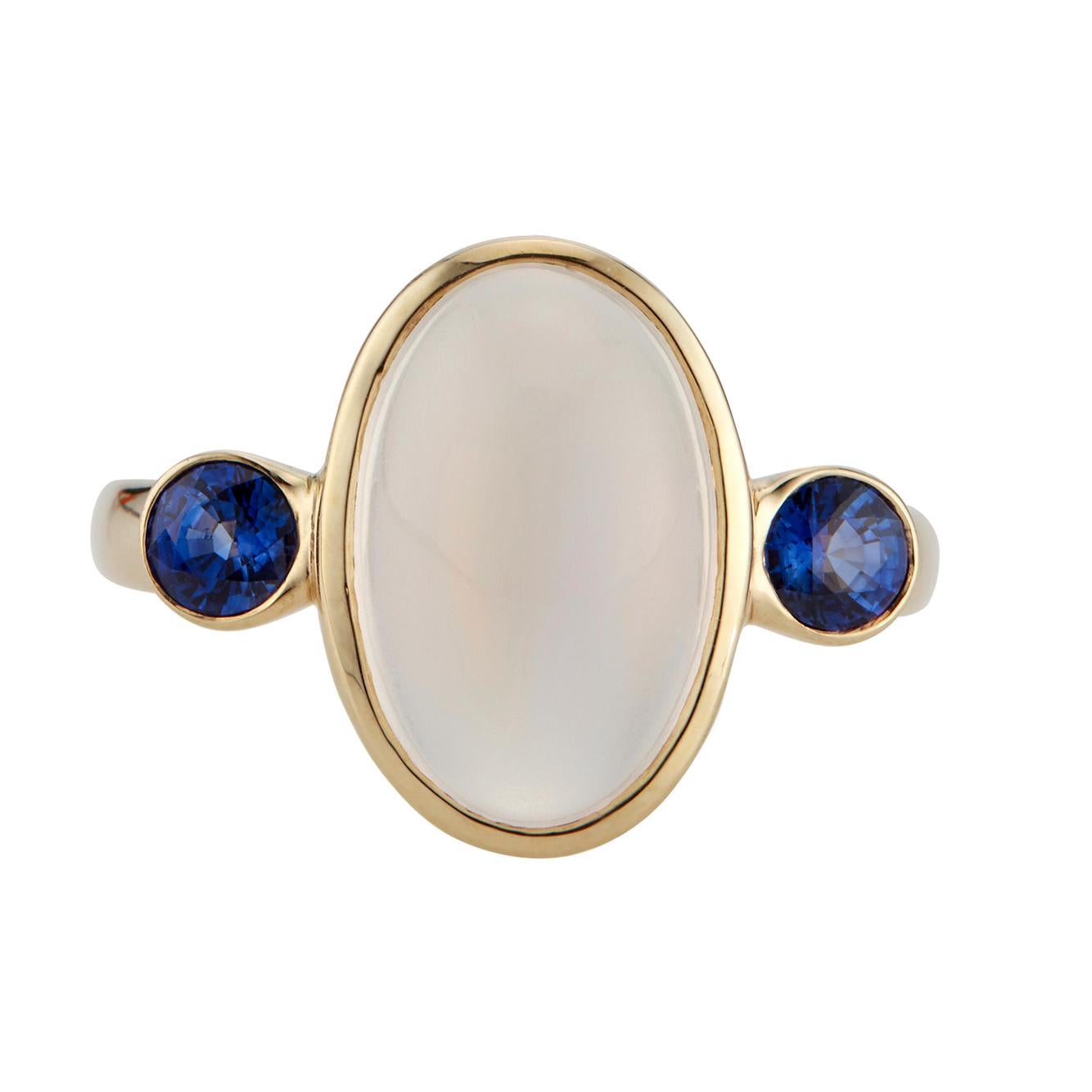 Handmade bezel set  moonstone and sapphire ring. Oval moonstone center stone with two bright round side sapphires in a 14k yellow gold setting. Designed and crafted in the Peter Suchy Workshop

1 oval blue cabochon Moonstone, approx. total weight