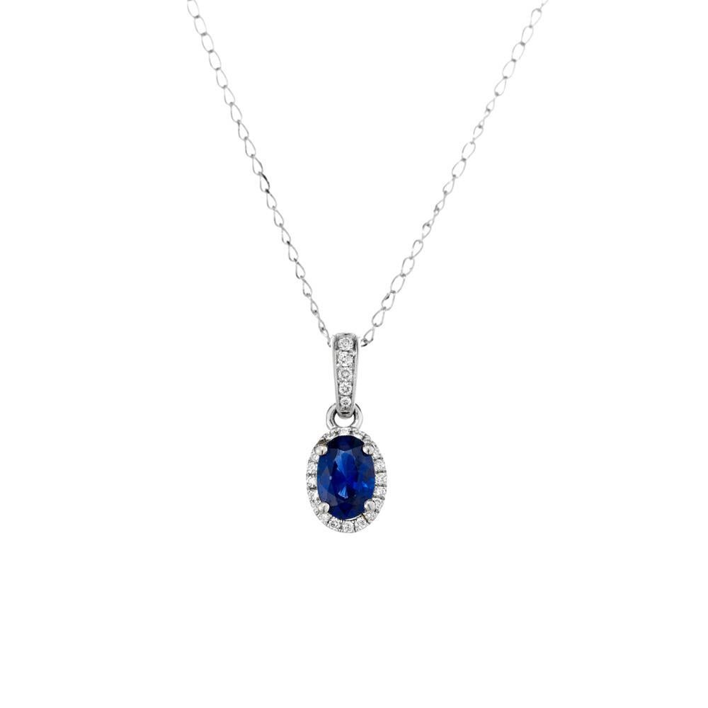 Sapphire and diamond pendant necklace.  .54 carat oval Ceylon sapphire set in 14k white gold with a halo of full cut diamonds enhanced with 5 full cut diamonds along the bail. 18 inch 14jk white gold chain. Designed and crafted in the Peter Suchy