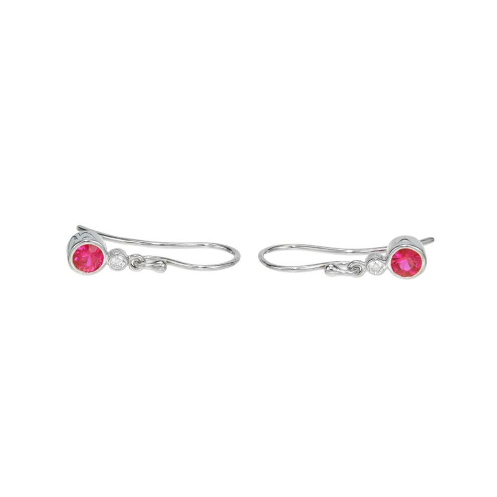 Ruby and diamond dangle earrings. 2 bright red rubies mounted in 18k white gold bezel set wire settings. Each accented with a round bezel set diamond. Designed and crafted in the Peter Suchy Workshop

2 round red rubies, approx. .55cts
2 round