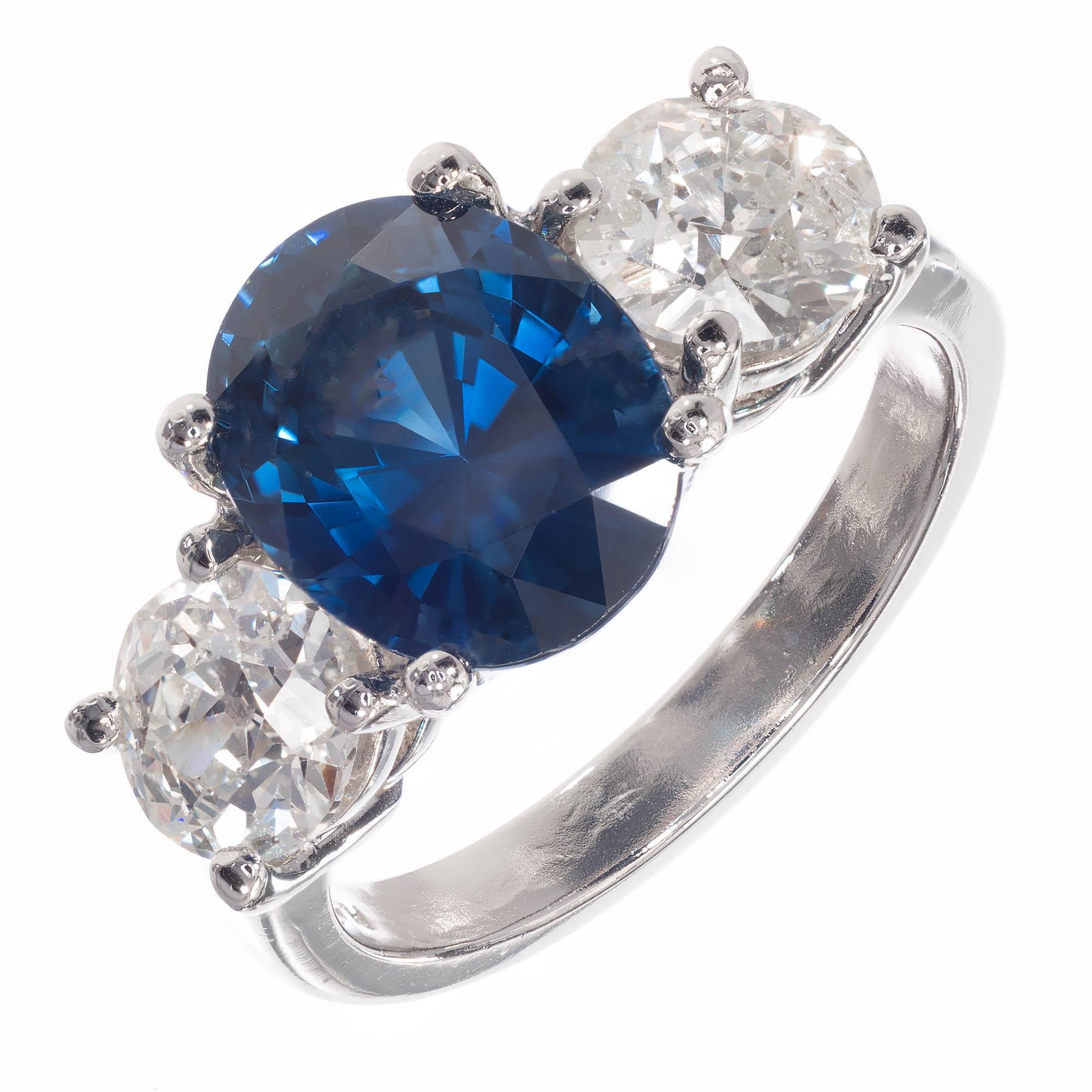 4.07 carat oval Sapphire and diamond three-stone engagement ring. Certified as natural color simple heat only with two old European cut diamonds with raised crowns and small tables set in a platinum setting from the Peter Suchy Workshop.

1 oval