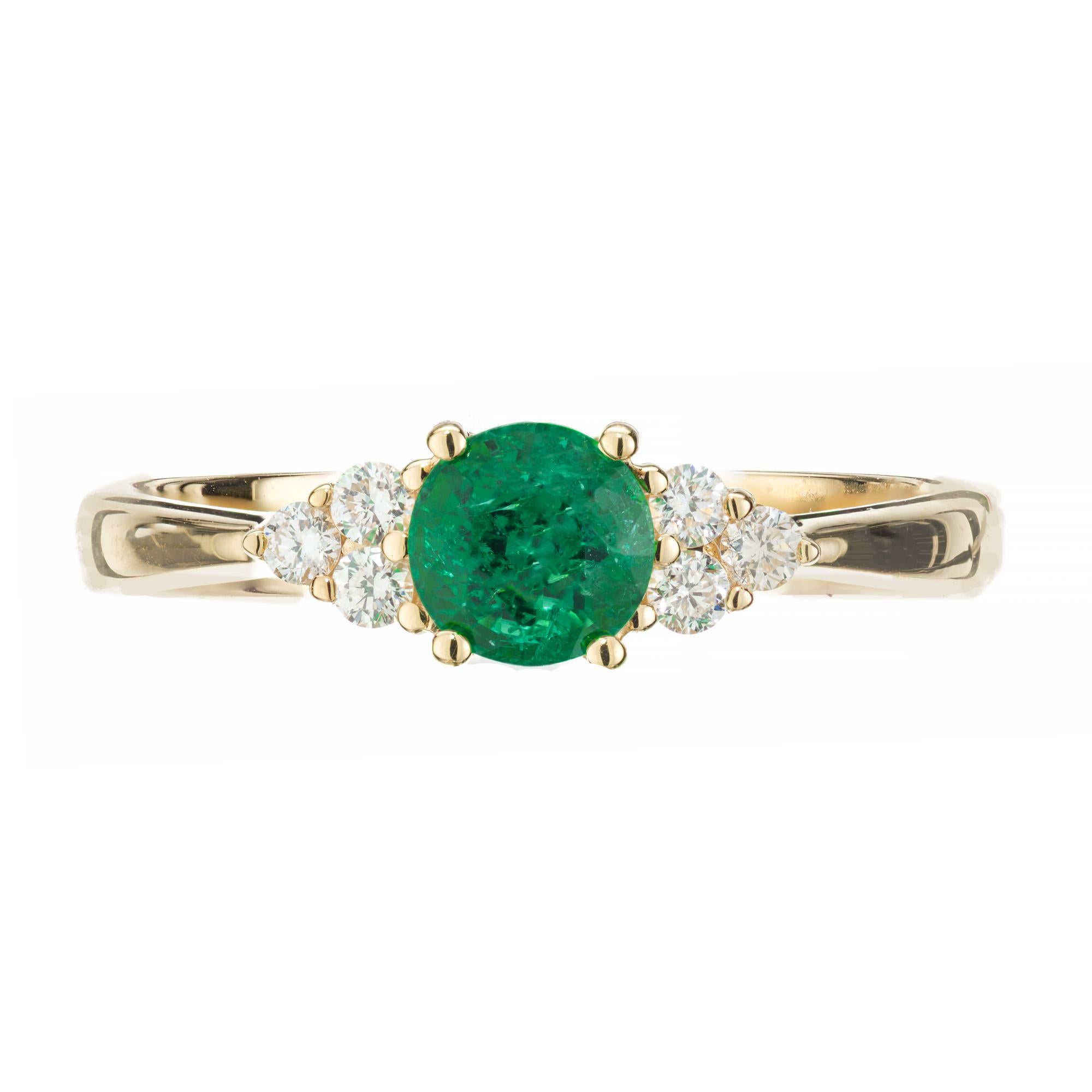 Emerald and diamond engagement ring. .58ct bright green round round emerald center stone set in at 18k yellow gold setting complemented with 3 round cut diamonds on each side of the stone. Designed and crafted in the Peter Suchy Workshop.

1 round