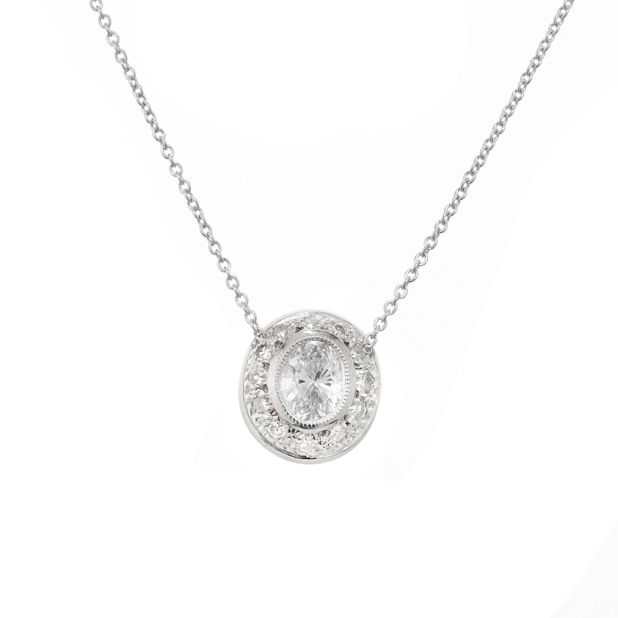 Antique style diamond slide pendant necklace. Created in the Peter Suchy Workshop, antique inspired, this platinum domed pendant has a .49ct oval bezel set center diamond, accented with a halo of 12 round Pavé set diamonds. 16 inch platinum cable