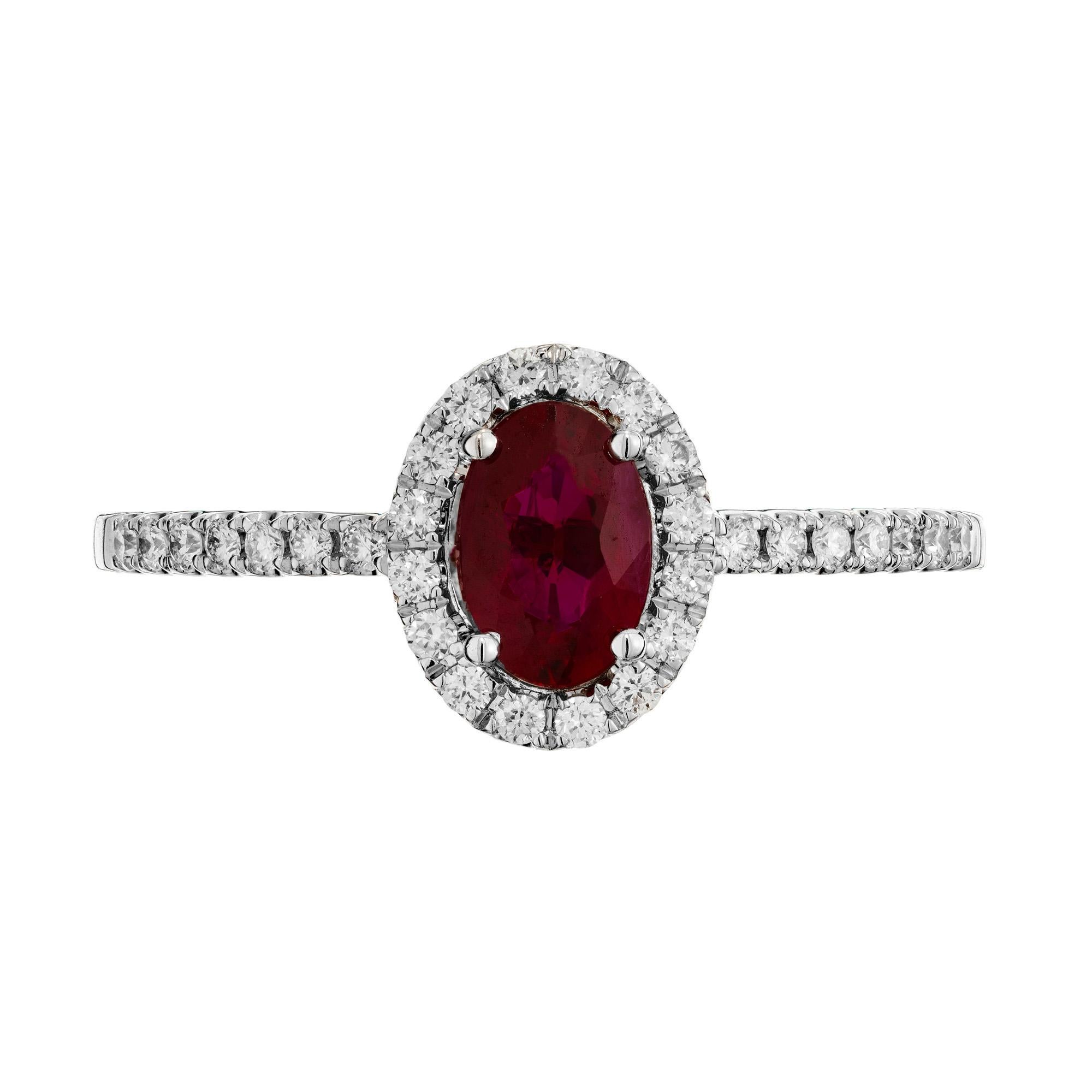 Bague de fiançailles en rubis naturel et diamant. Pierre centrale ovale en rubis de 0,60ct, montée dans une monture en or blanc 14k avec un halo de diamants ronds de taille brillant. Chaque épaule est également ornée de 7 diamants ronds de taille