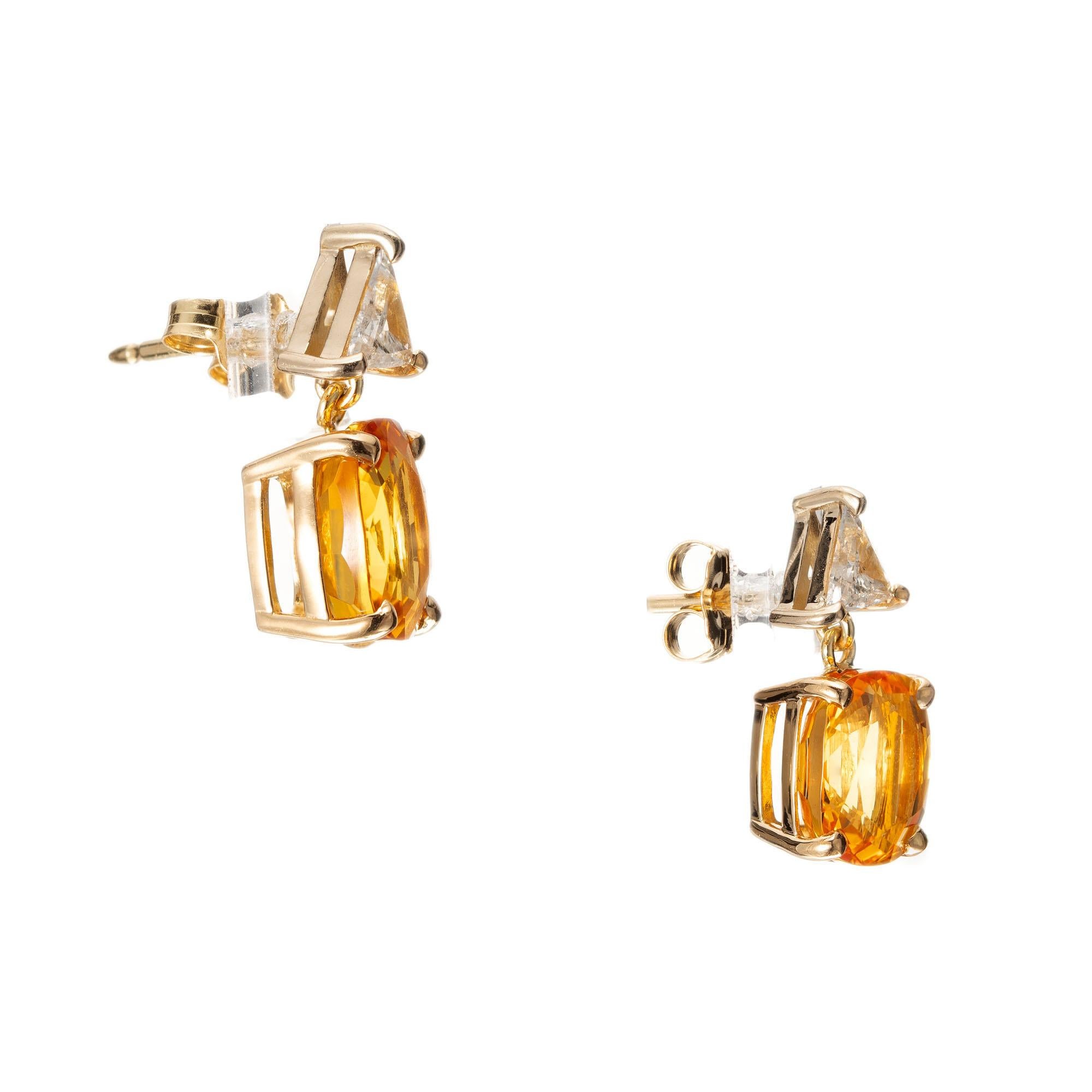GIA certified sapphire and diamond dangle earrings. 2 Cushion cut orange yellow sapphires. Beryllium treated for a bright orange yellow color. Accented with 2 trilliant cut diamonds, in 18k yellow gold settings. Created in the Peter Suchy Workshop.