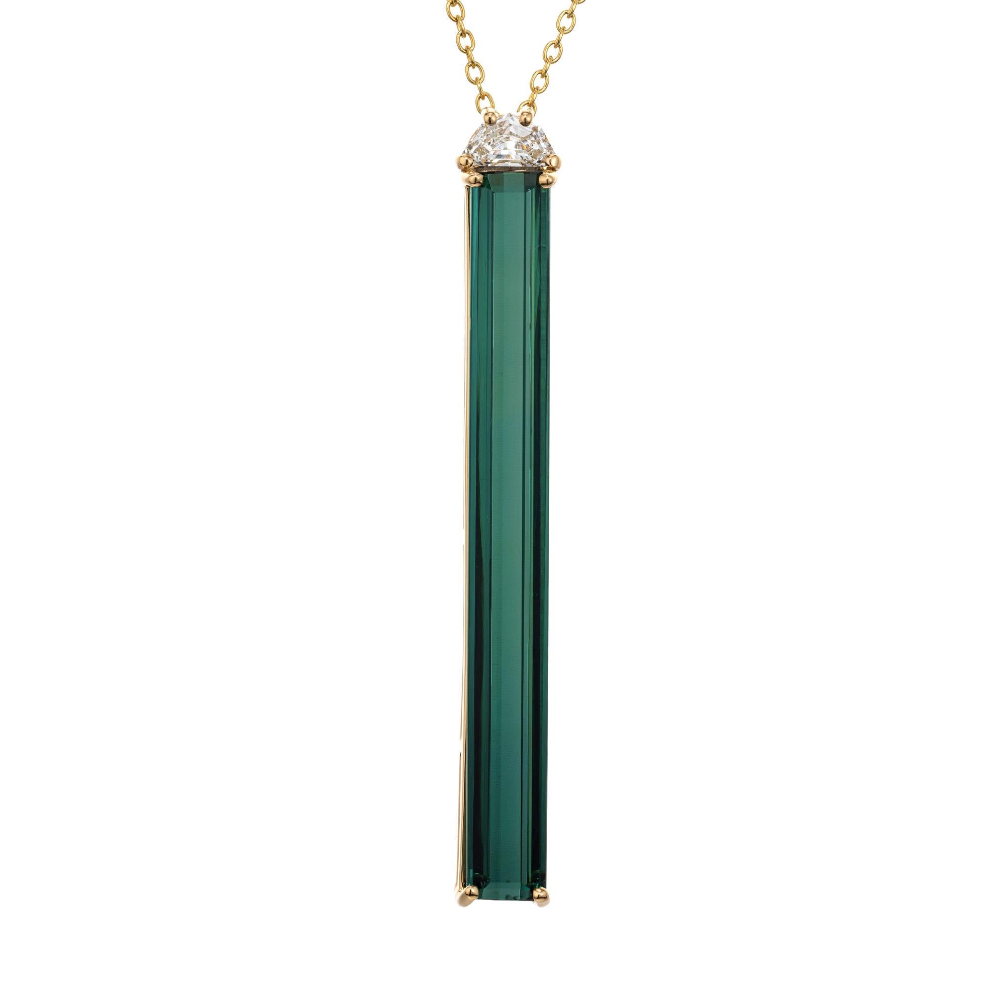 This unique and rare Tourmaline and diamond pendant necklace comes from the Peter Suchy Workshop. 6.50 carat elongated emerald cut deep green tourmaline is set in four prong 18k yellow gold setting. A half moon accent diamond sits atop of the