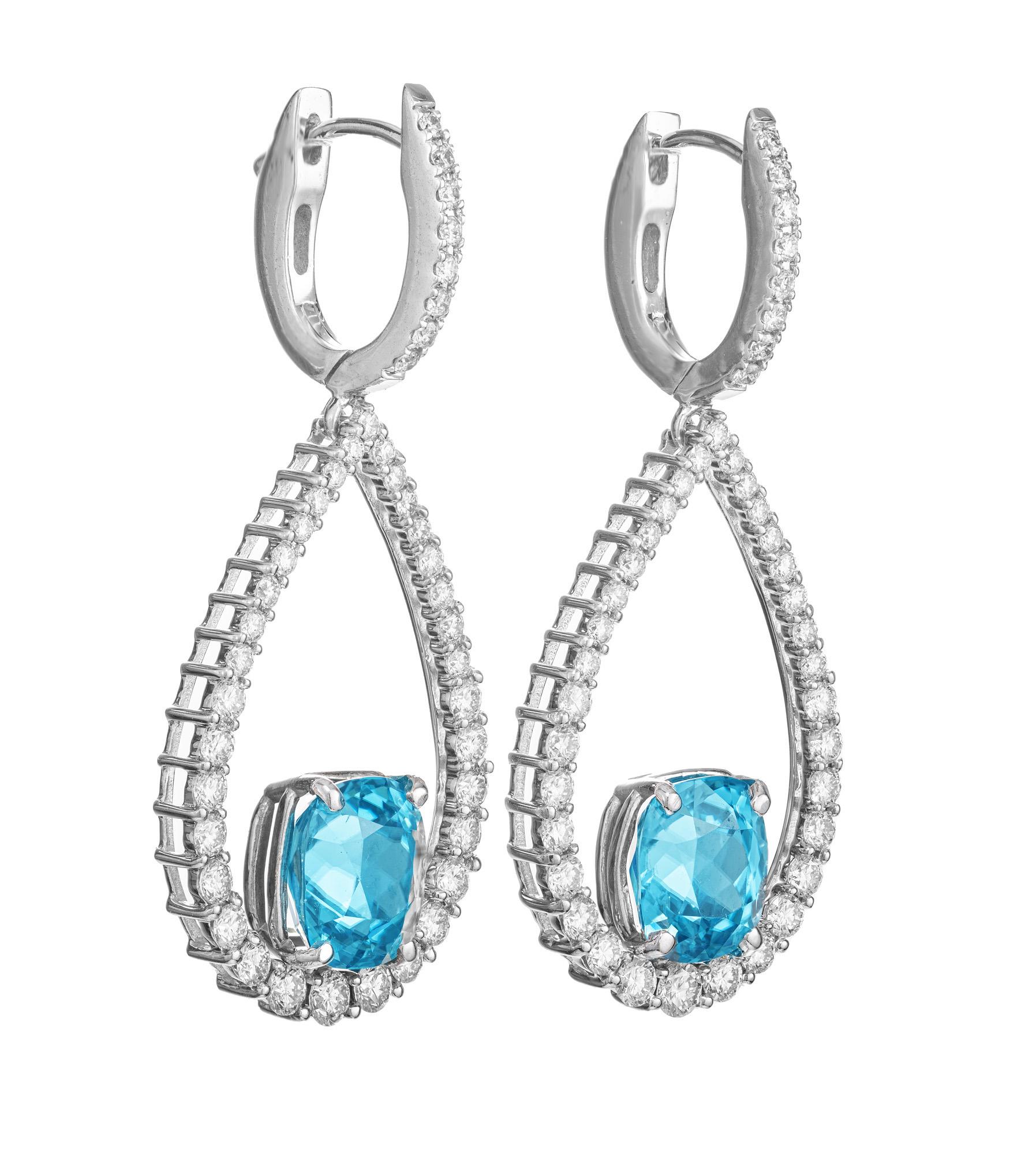 Teal blue zircon and diamond dangle earrings. 2 cushion cut bright teal zircons sit at the bottom of each open pear shaped diamond dangle with a total carat weight of 6.97cts. The diamond hoop tops and dangles are adorned with 84 round full cut