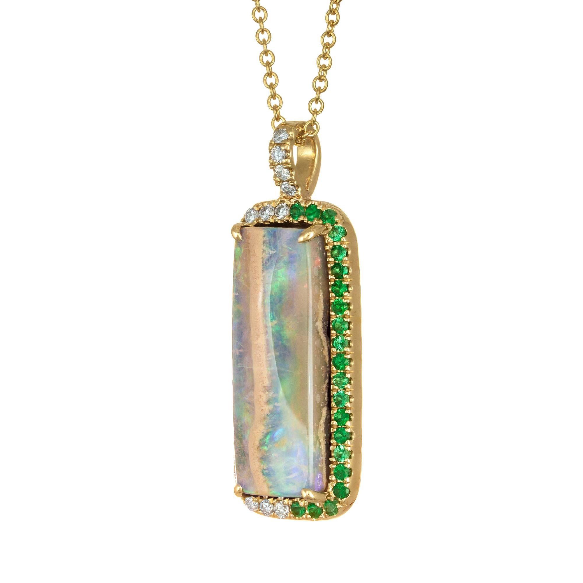 Green boulder opal from Australia. Natural and untreated with a micro pave diamond and emerald halo in 14k yellow gold.  From the Peter Suchy workshop

1 rectangular (red orange blue green) black opal, approx. 7.32ct
25 round brilliant cut diamonds
