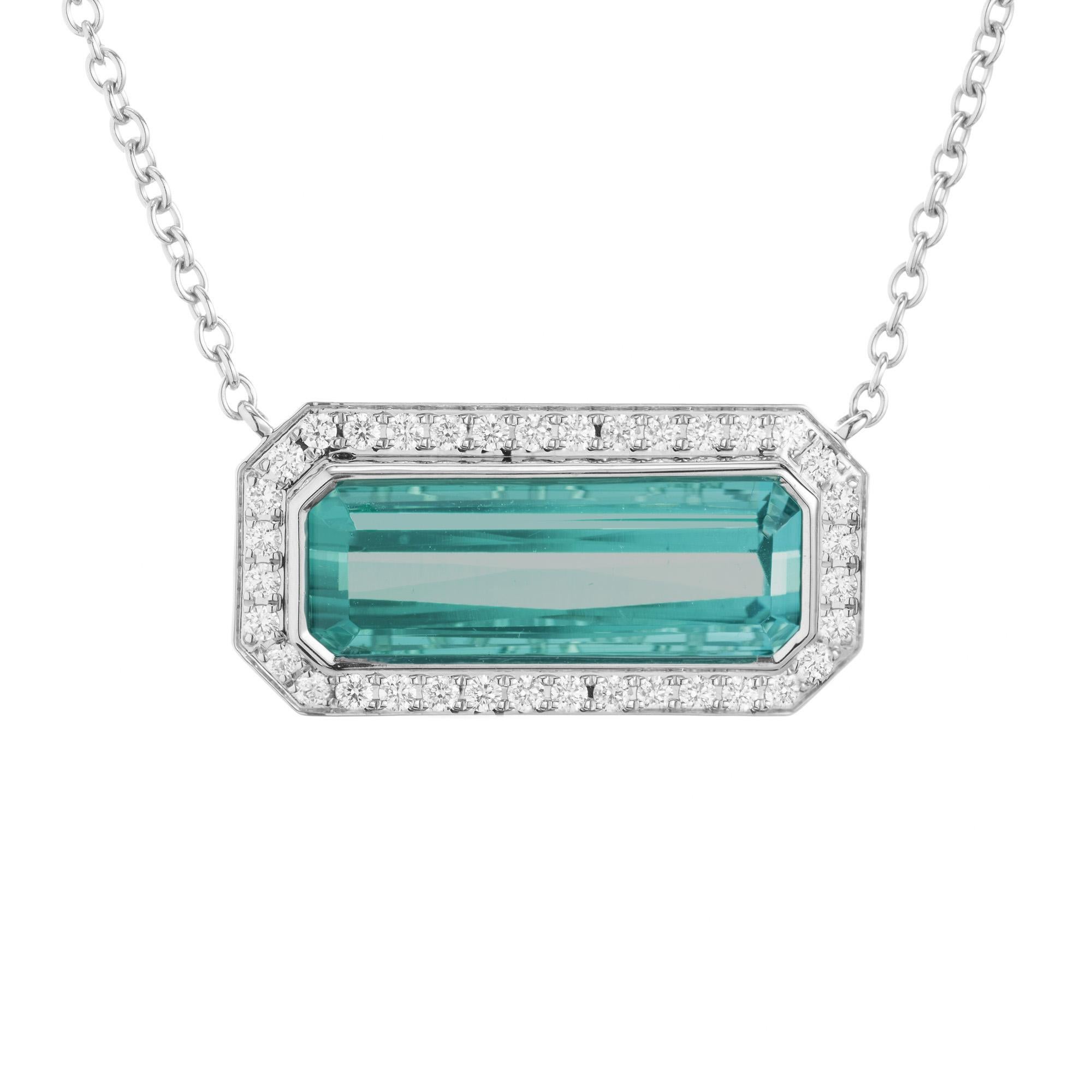 The Peter Suchy Tourmaline and Diamond pendant necklace. This stunning piece centers around a mesmerizing 7.42ct elongated rectangular greenish blue tourmaline set horizontally. Encircling the tourmaline are 36 meticulously set round brilliant cut