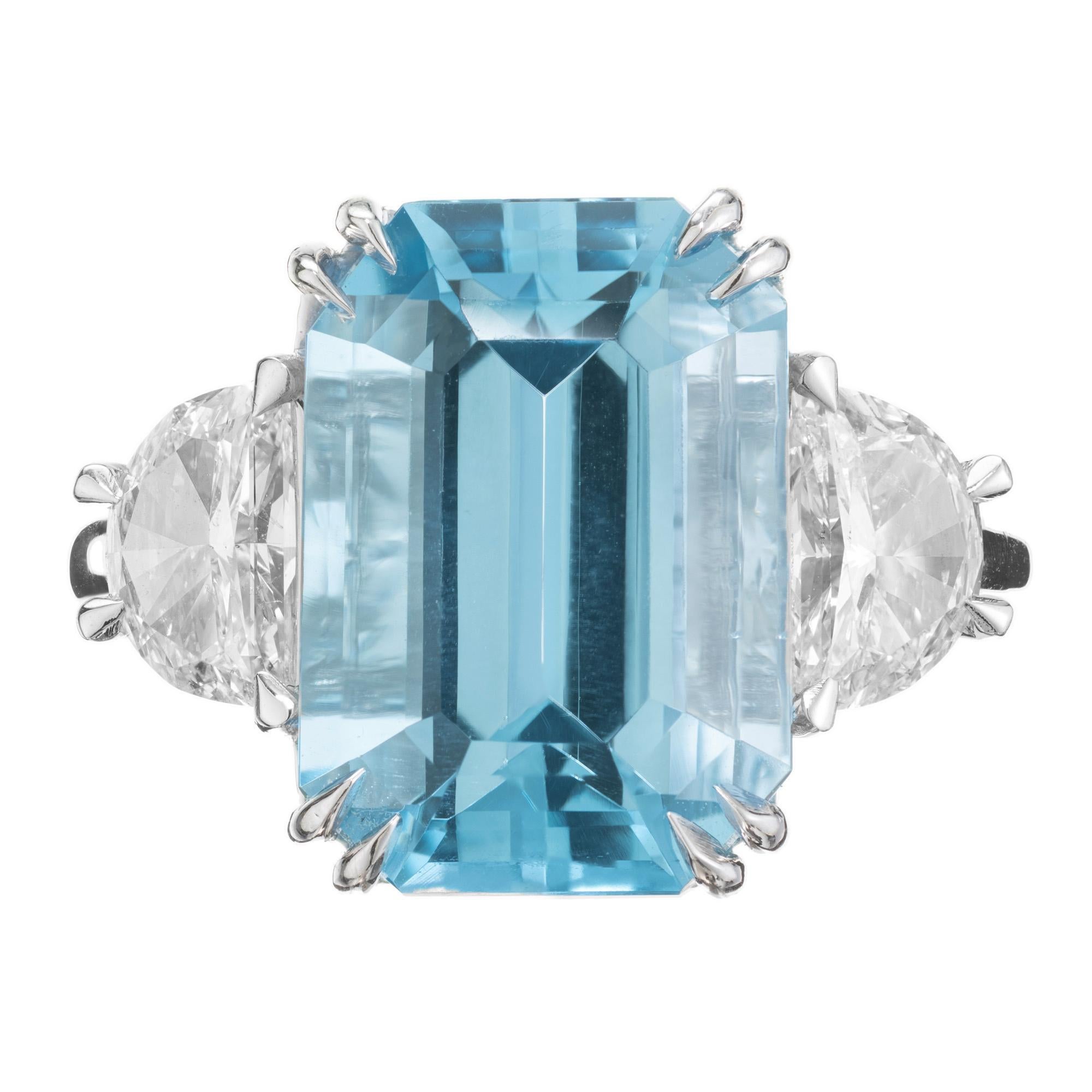 Aqua and diamond three-stone engagement ring. 7.44ct octagonal shape aquamarine mounted securely in a platinum 8 pong setting and accented with 2 half moon side diamonds totaling 1.17cts. One of the finest crisp greenish blue aquas we have come