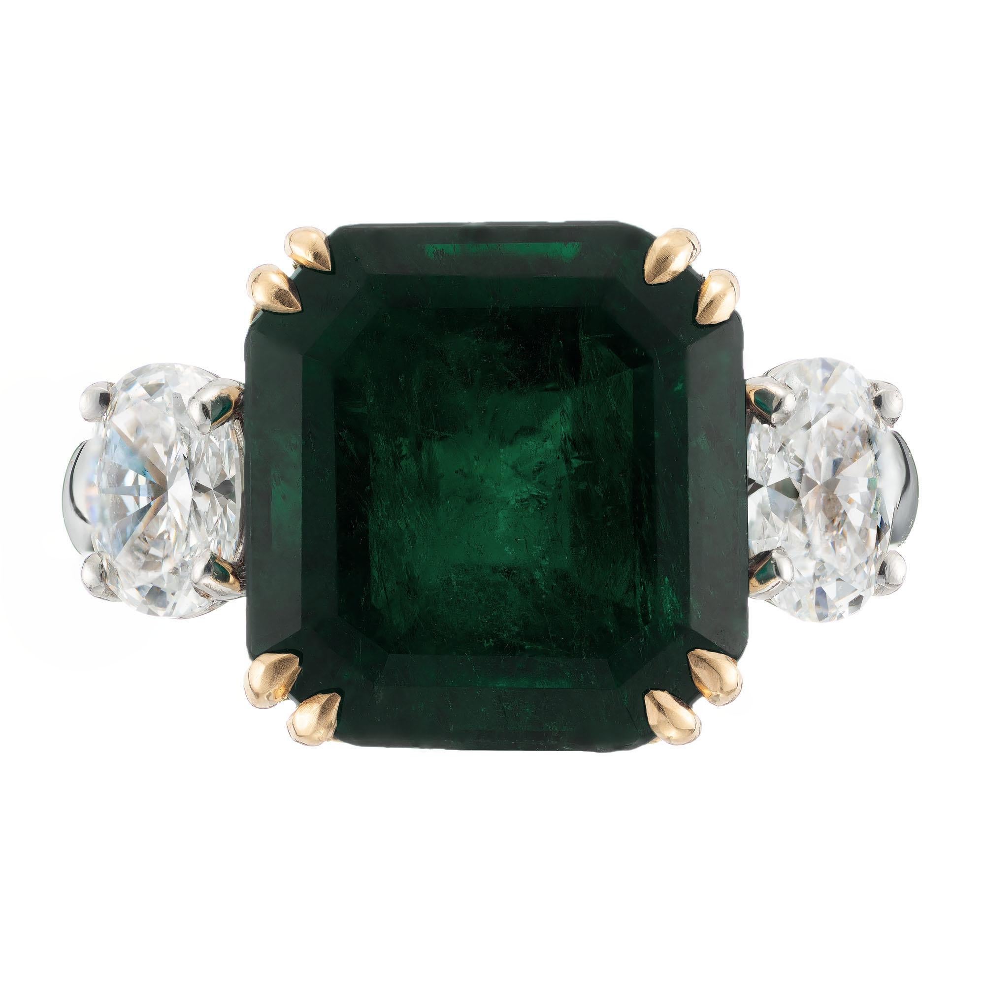 Colombian emerald and diamond engagement ring. 7.50 carat AGL certified center minor clarity enhancement. Accented with two GIA certified oval side diamonds in a 18k yellow gold and platinum setting crafted in the Peter Suchy Workshop. 

1