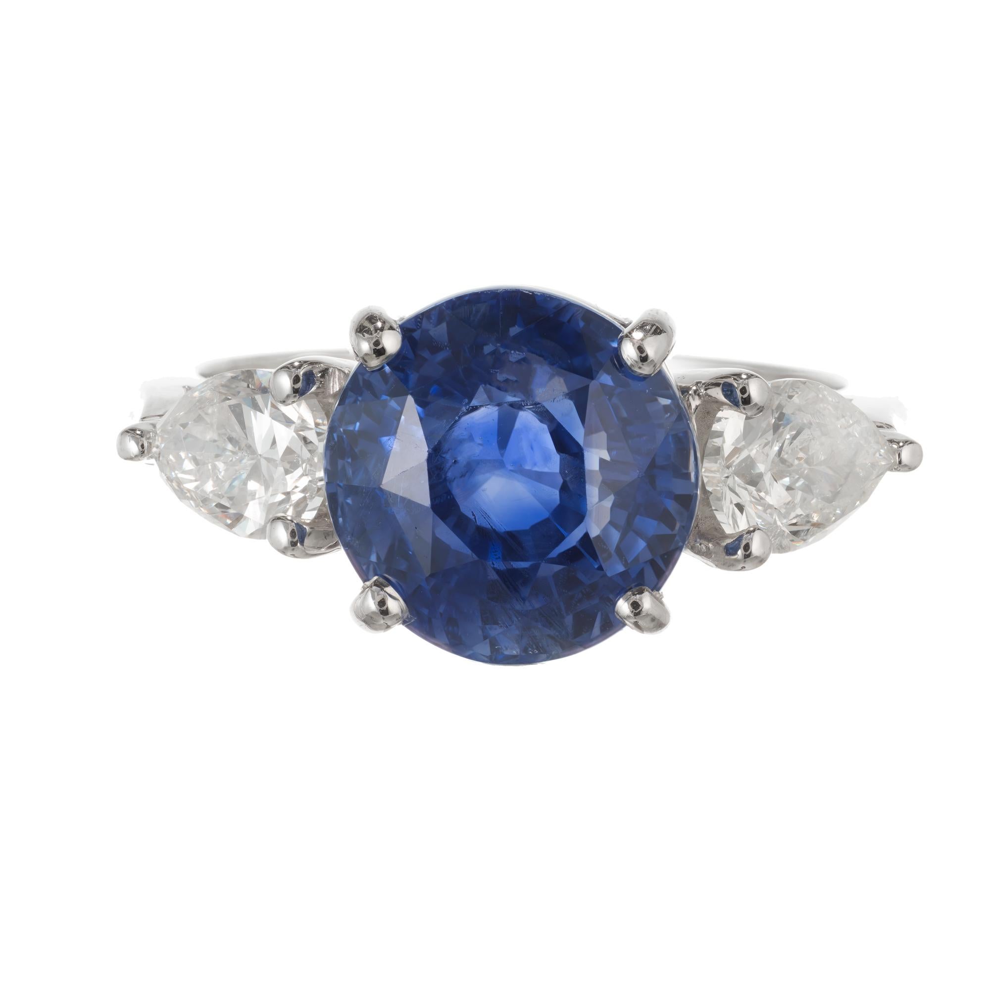 Vibrant blue sapphire and diamond engagement ring. Natural no heat round old European cut center Sapphire GIA certified in a platinum three-stone setting with two pear shaped side diamonds, created by the Peter Suchy Workshop. 

1 round vibrant blue