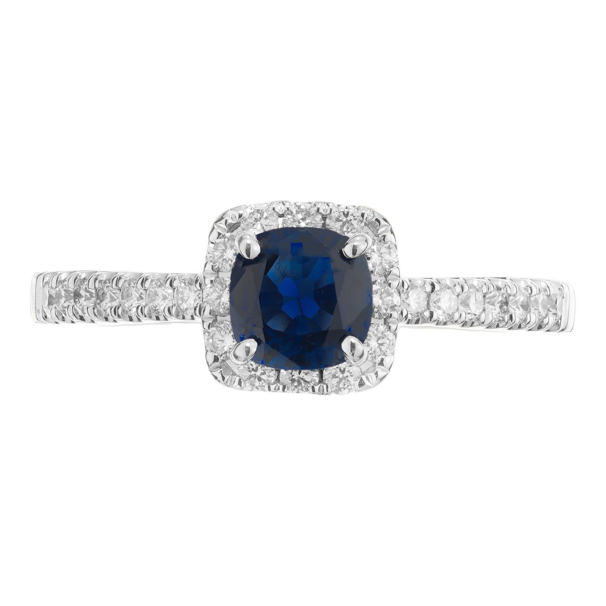 Rich blue cushion cut sapphire in a classic 14k white gold halo ring. .77ct cushion cut blue center sapphire. Mounted in a 14k white gold diamond halo setting. Each shoulder is adorned with 7 round brilliant cut diamonds. Crafted with precision and