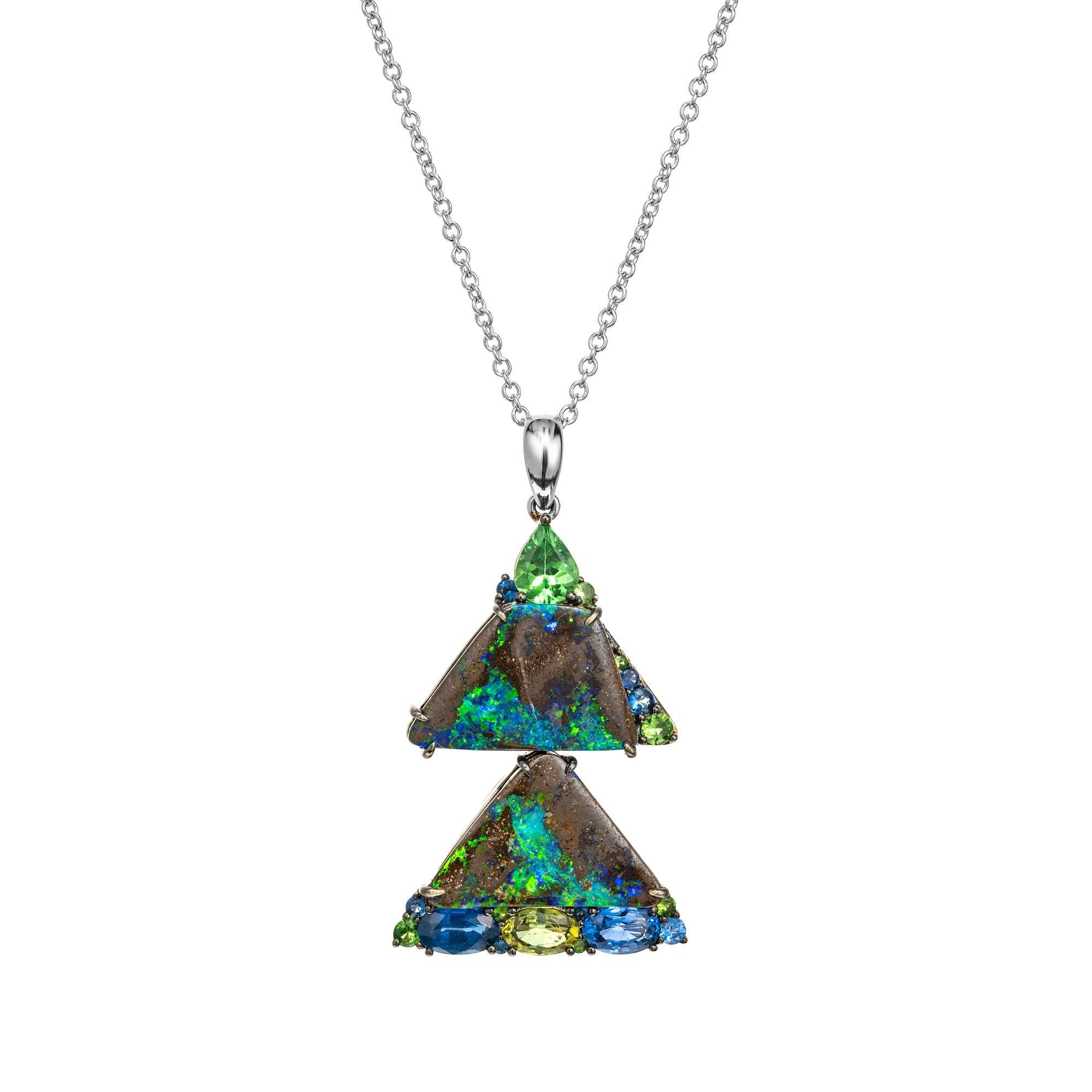 Truly a one of a kind natural green flash boulder opal pendant necklace with natural sapphires and garnet accents. Mounted in 18k white gold, the opals have a kaleidoscope of colors and captures the essence of a tranquil summer night sky, while the