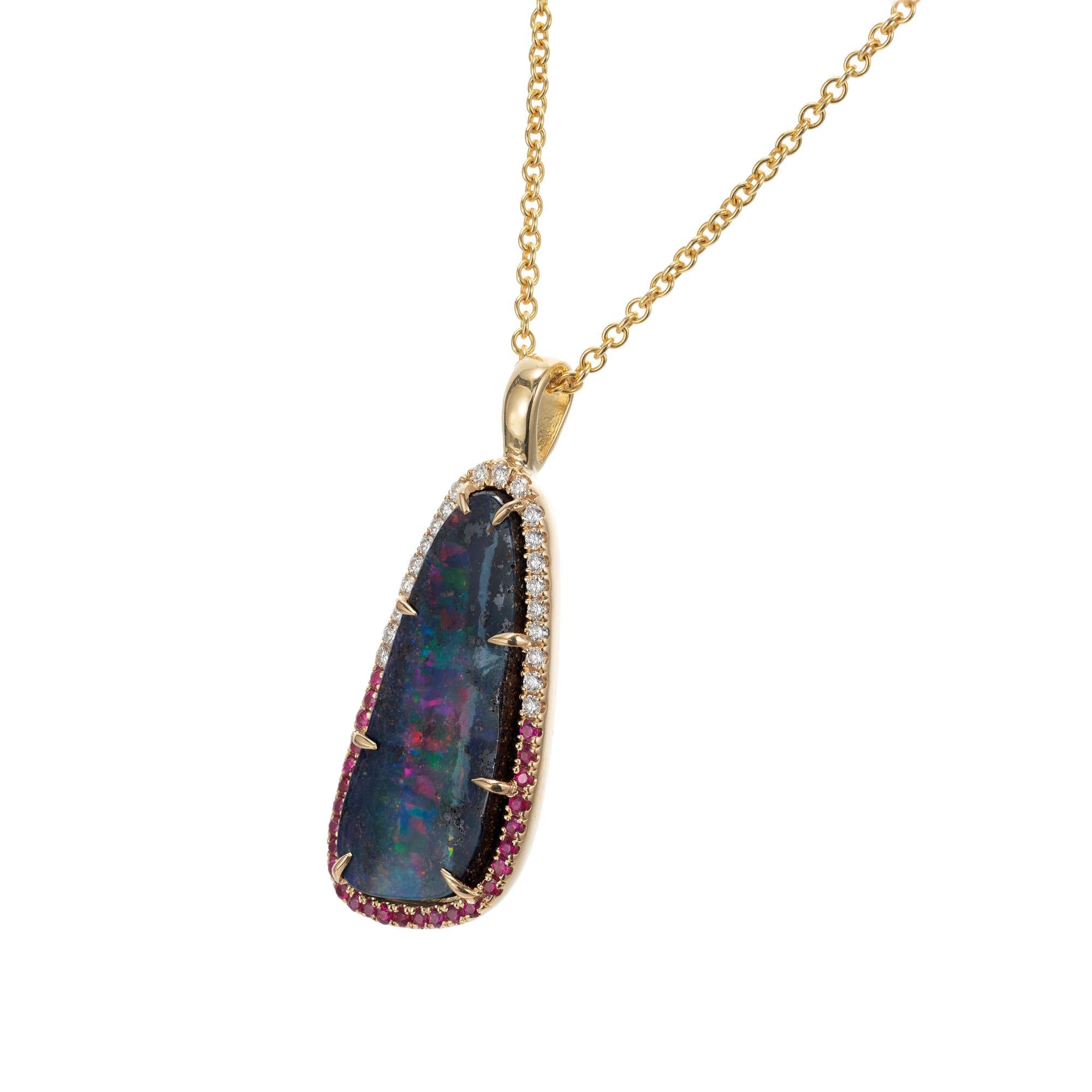 Natural Australian boulder opal necklace with a halo of rubies and diamonds. The opal has bluish black background with red, green and purple flash.  The pendant was designed in the Peter Suchy workshop

1 Australian boulder opal, approx. 8.16ct
27