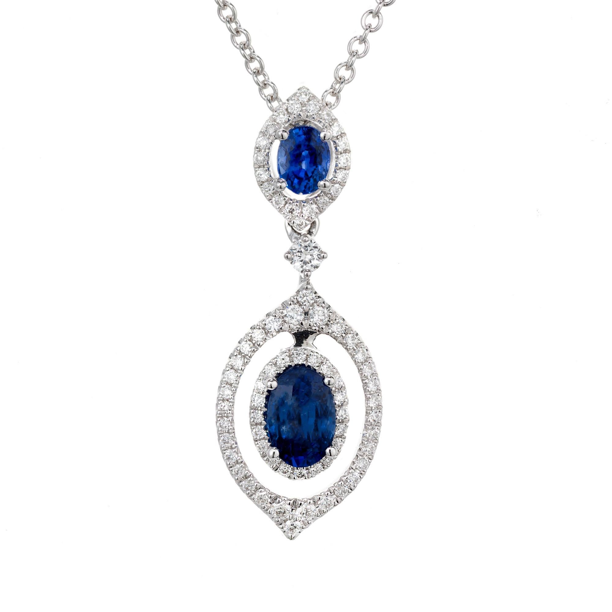 Sapphire and diamond 18k white gold pendant necklace. 2 oval sapphires with halos of round cut diamonds. A single cut single cut diamond separates the two sapphires. The bottom sapphire dangles and has a double halo. 16 inch 18k white gold chain.