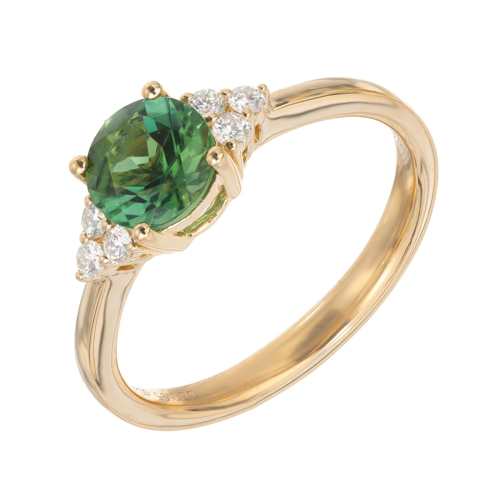 Bright green tourmaline and diamond engagement ring. .95ct round cut center tourmaline accented with three round brilliant cut diamonds on each side of the stone and mounted in a 18k yellow gold setting designed and crafted in the Peter Suchy