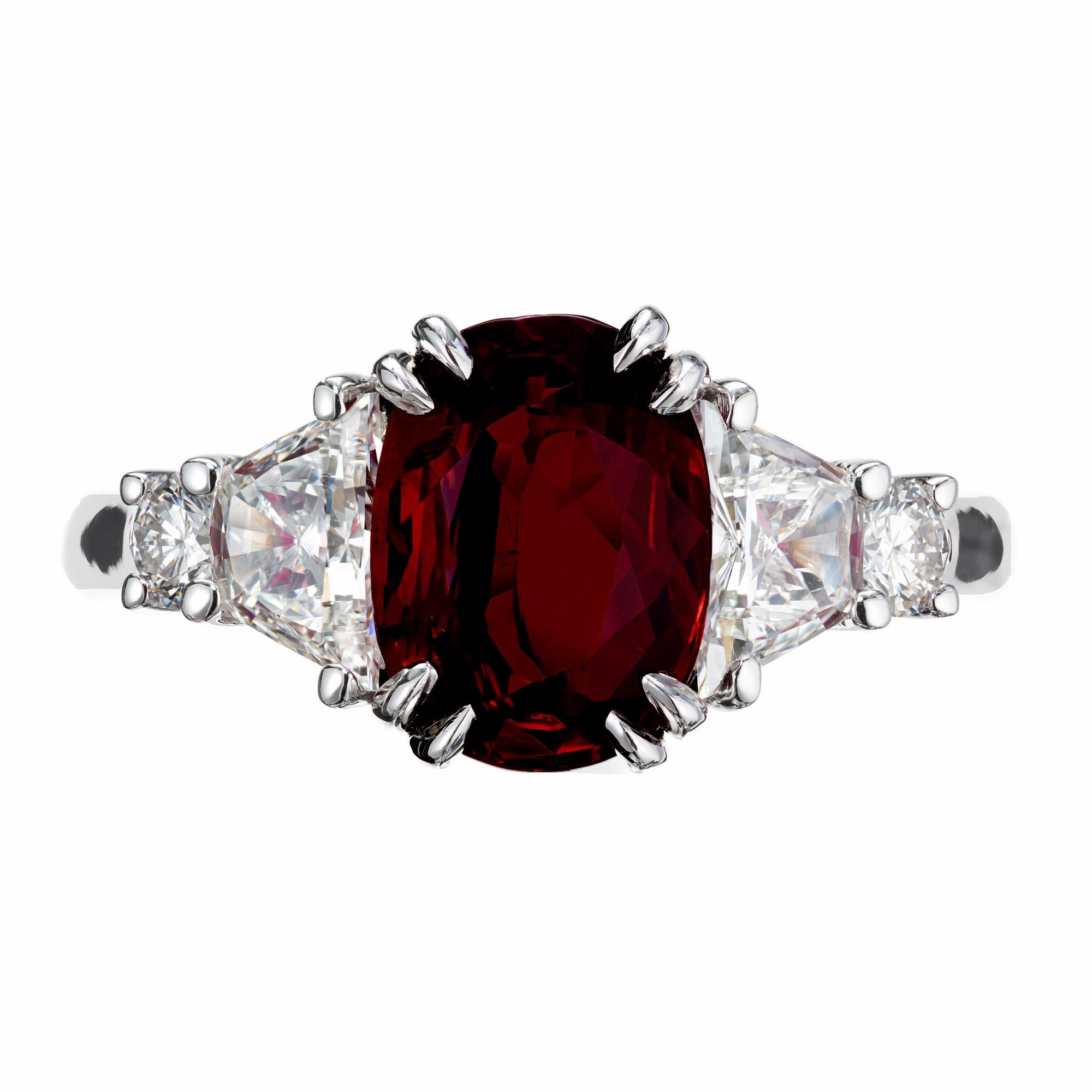 Ruby and diamond engagement ring. GIA certified crimson red oval 2.96ct Ruby set in a platinum 8 prong setting, accented by two brilliant cut trapezoid and full round cut diamonds. The GIA has certified this ruby as a natural with simple heat only.
