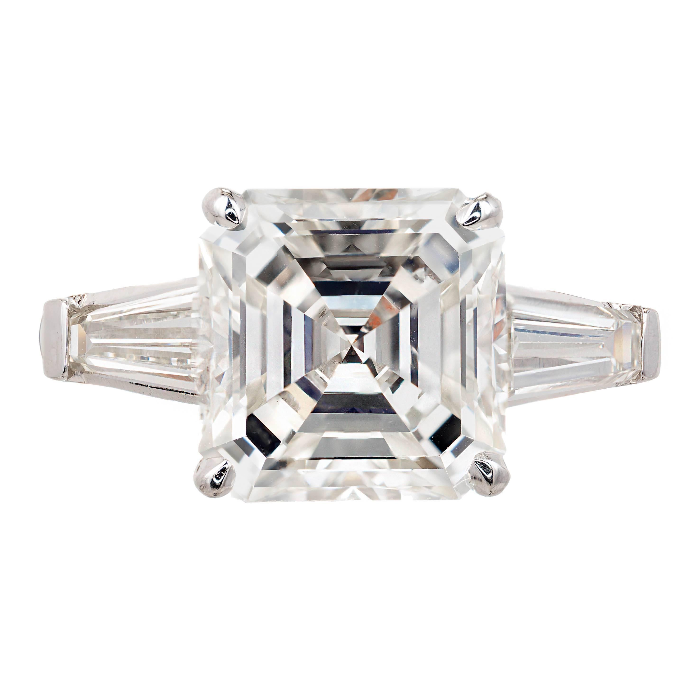 Spectacular Asscher cut 4.41ct diamond three-stone platinum engagement ring. The Asscher cut center stone is certified by both the GIA and EGL.  GIA certifies it as K (faint yellow) and VVS2 ( Very Very Slightly included, barely visible at 10x