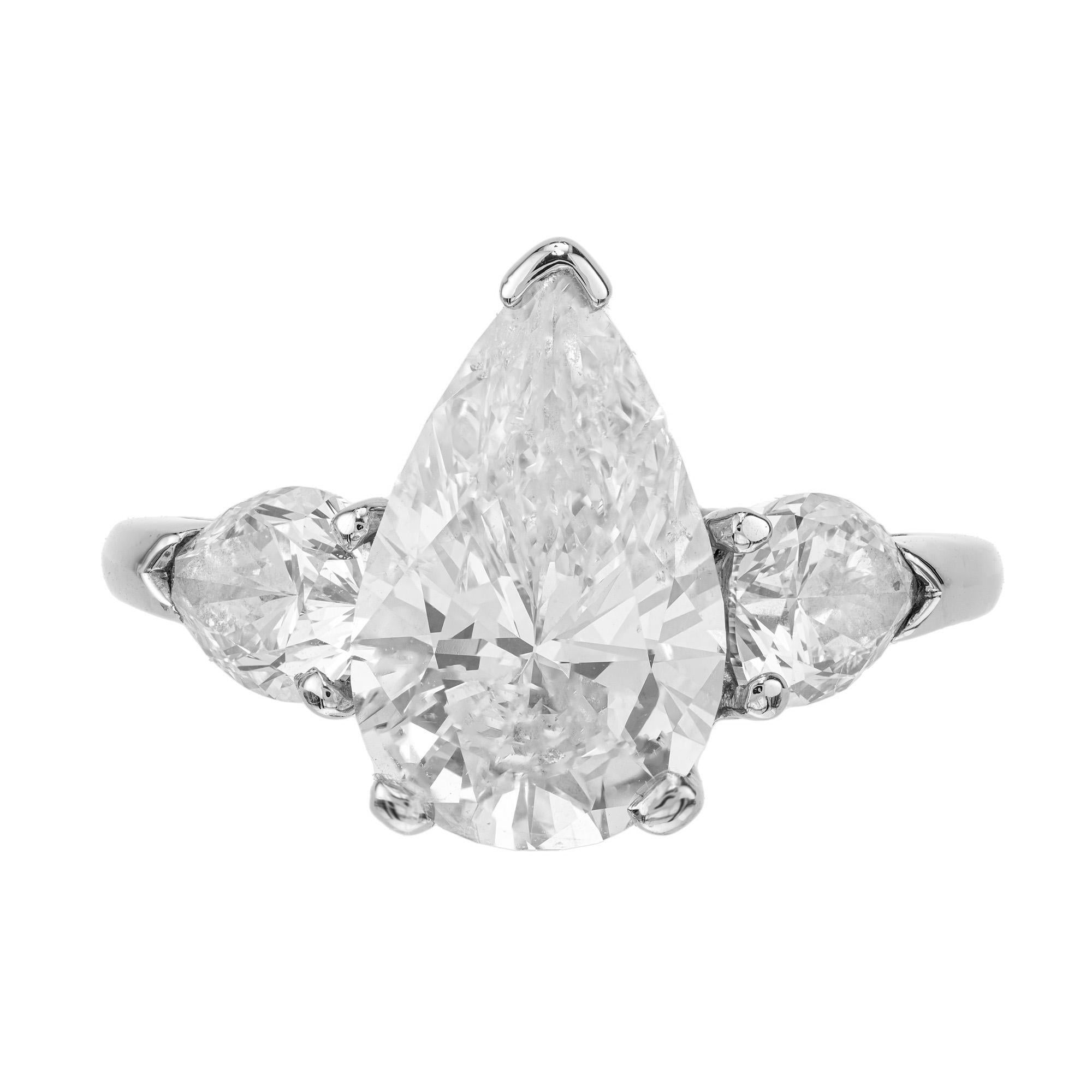 Stunning and exquisite three stone ring features a dazzling 4.02 carat EGL certified center stone. The centerpiece is accented pear shaped diamonds that are set sideways, creating a stunning display of elegance and sophistication. The setting is