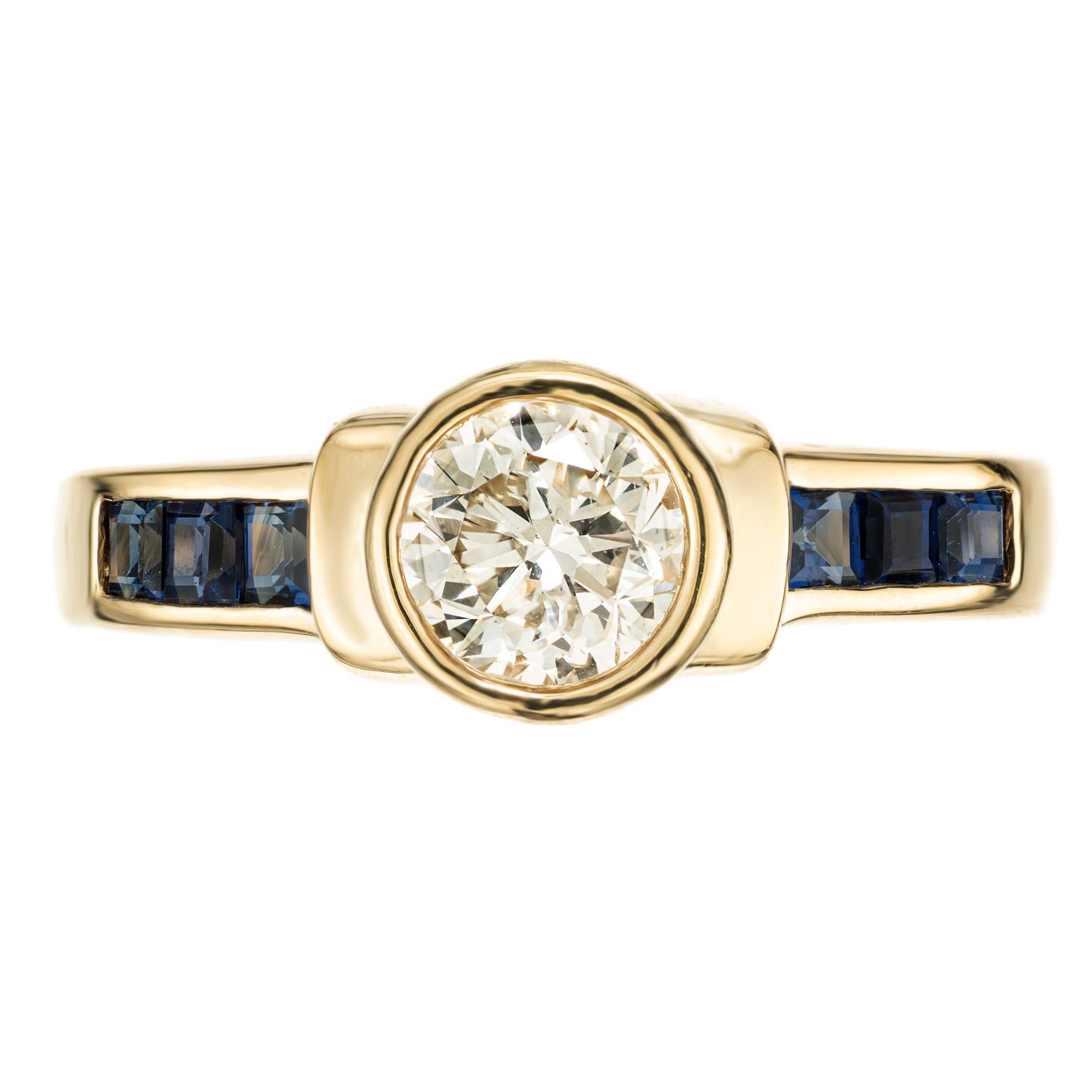 Experience timeless elegance with the Peter Suchy EGL .71ct Diamond and Sapphire engagement ring. This unique bezel setting features a .71ct transitional cut center diamond mounted in 14k yellow gold setting. Each shoulder is adorned with three