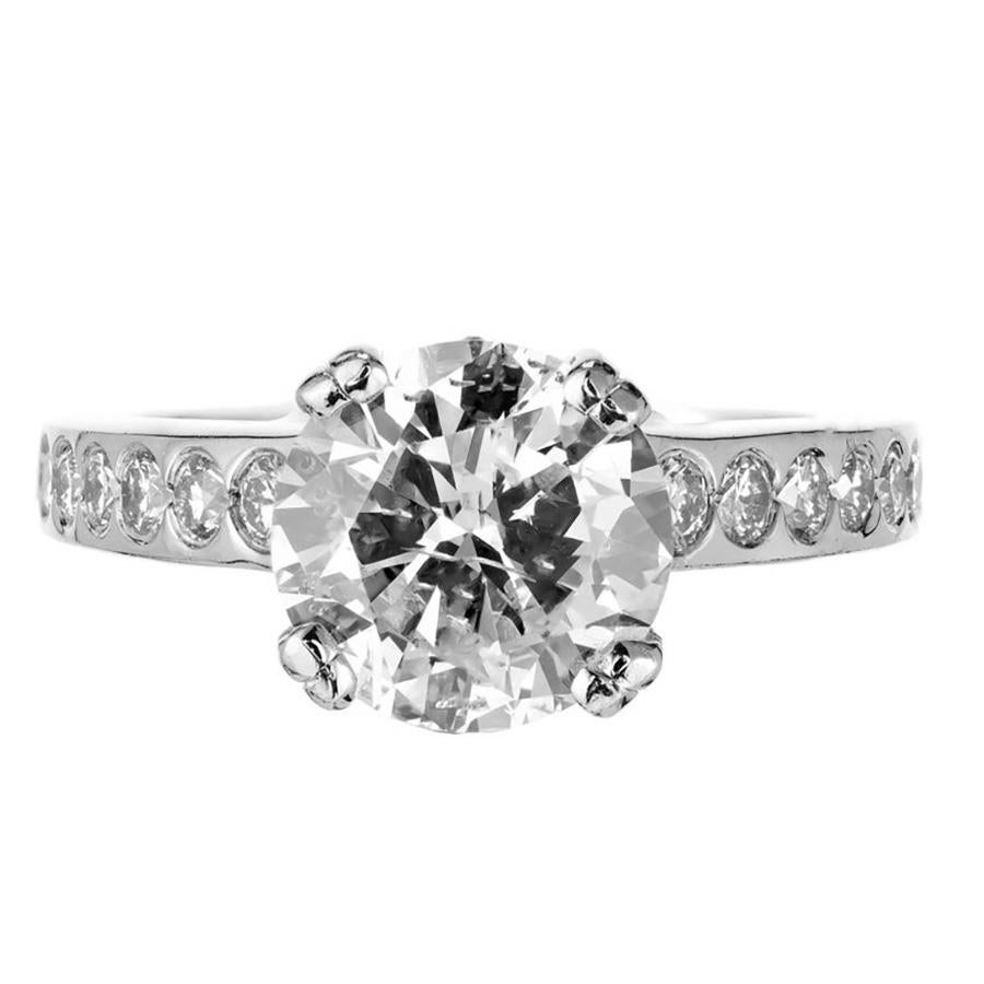 Solitaire Diamond engagement ring. EGL certified 2.44 round brilliant cut center diamond mounted in a double prong platinum setting. Graded G to H nearly colorless, both shoulders are uniquely adorned with full cut round diamonds that are set below