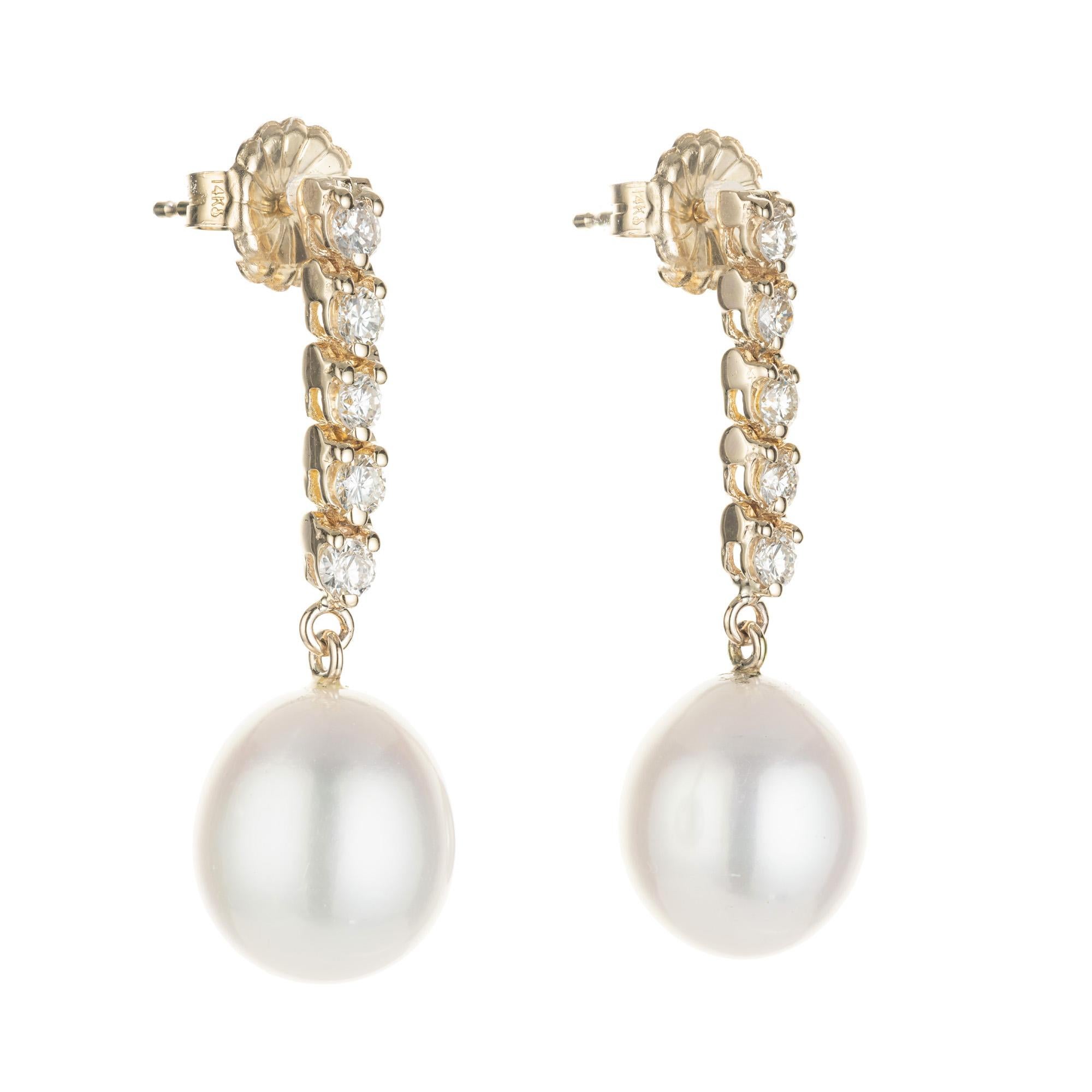 Freshwater and diamond dangle drop earrings. Two 11mm to 11.5mm freshwater pearls, each dangling from 5 round brilliant cut diamonds in 14k yellow gold.  Designed and crafted in the Peter Suchy Workshop. 

2 freshwater white pearls, 11mm -11.5mm
10