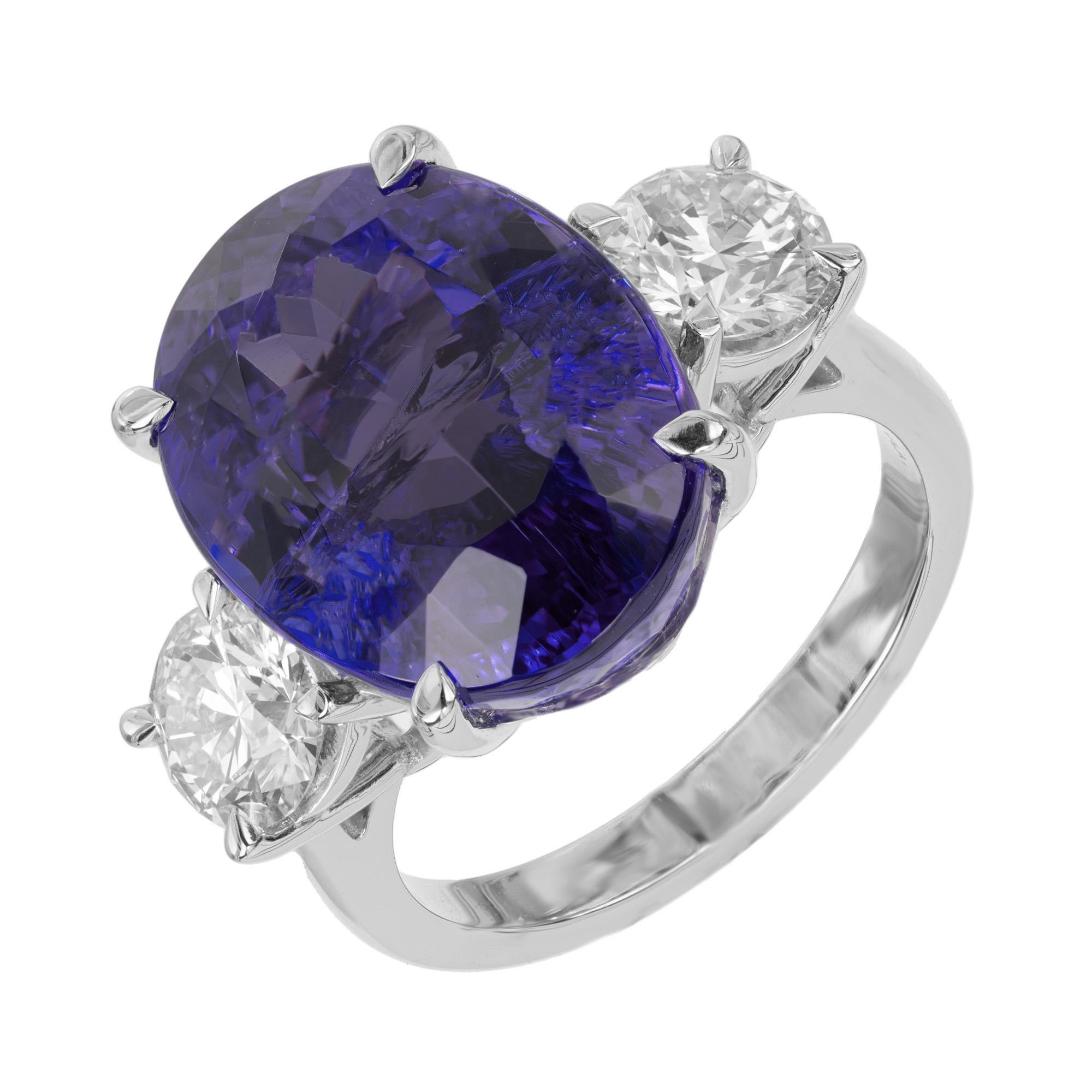 Breathtaking and spectacular Earth mined oval tanzanite and diamond engagement ring. At the heart of the three stone ring is a mesmerizing 14.07ct oval violet blue tanzanite center stone, mounted in a platinum setting. Gemstone is enriched by two