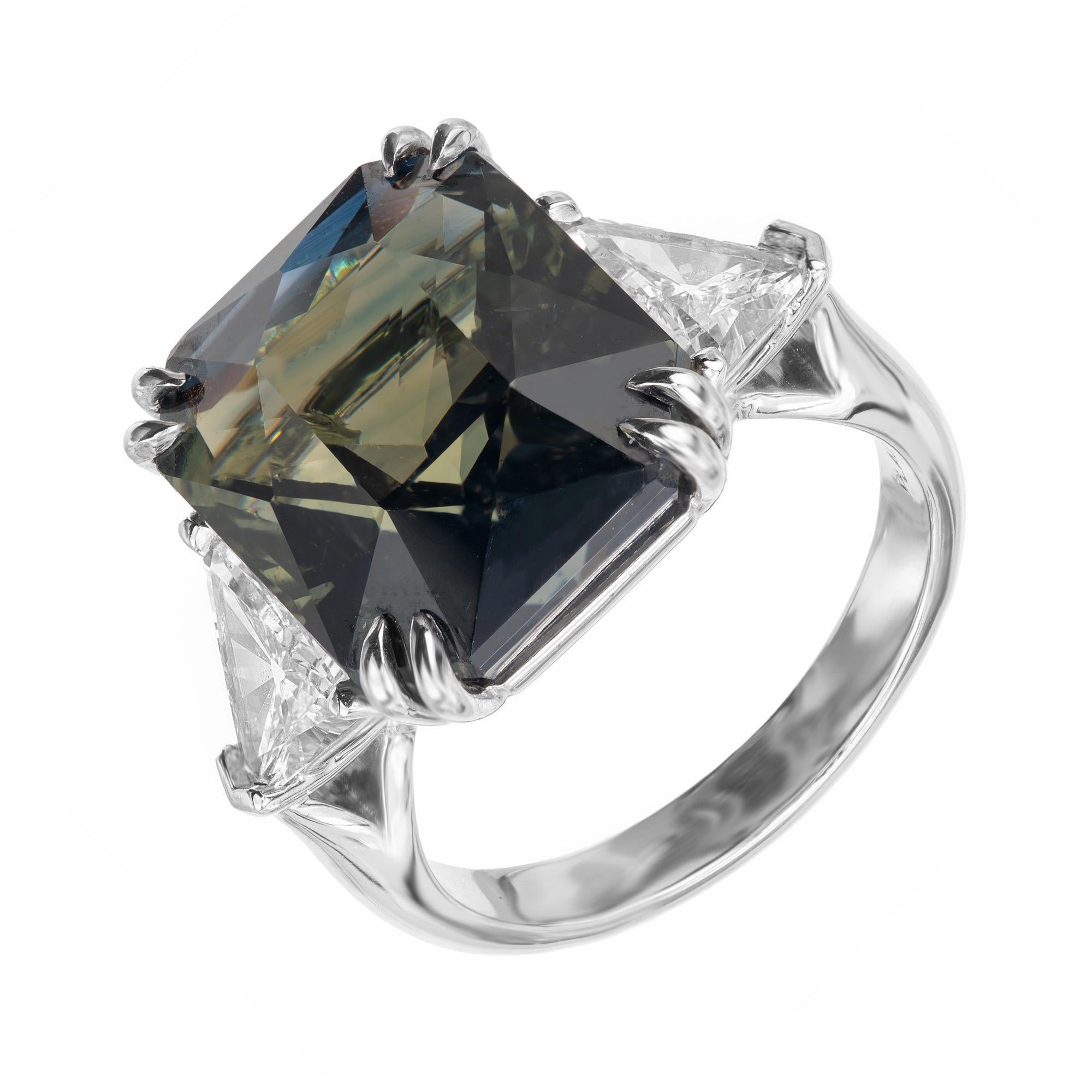 Anillo de tres piedras de zafiro y diamantes talla ocatgonal. La piedra central es una rica mezcla de color azul y verde, acentuada por dos diamantes laterales de talla trillante en un engaste de platino de tres piedras. Certificado GIA natural sin