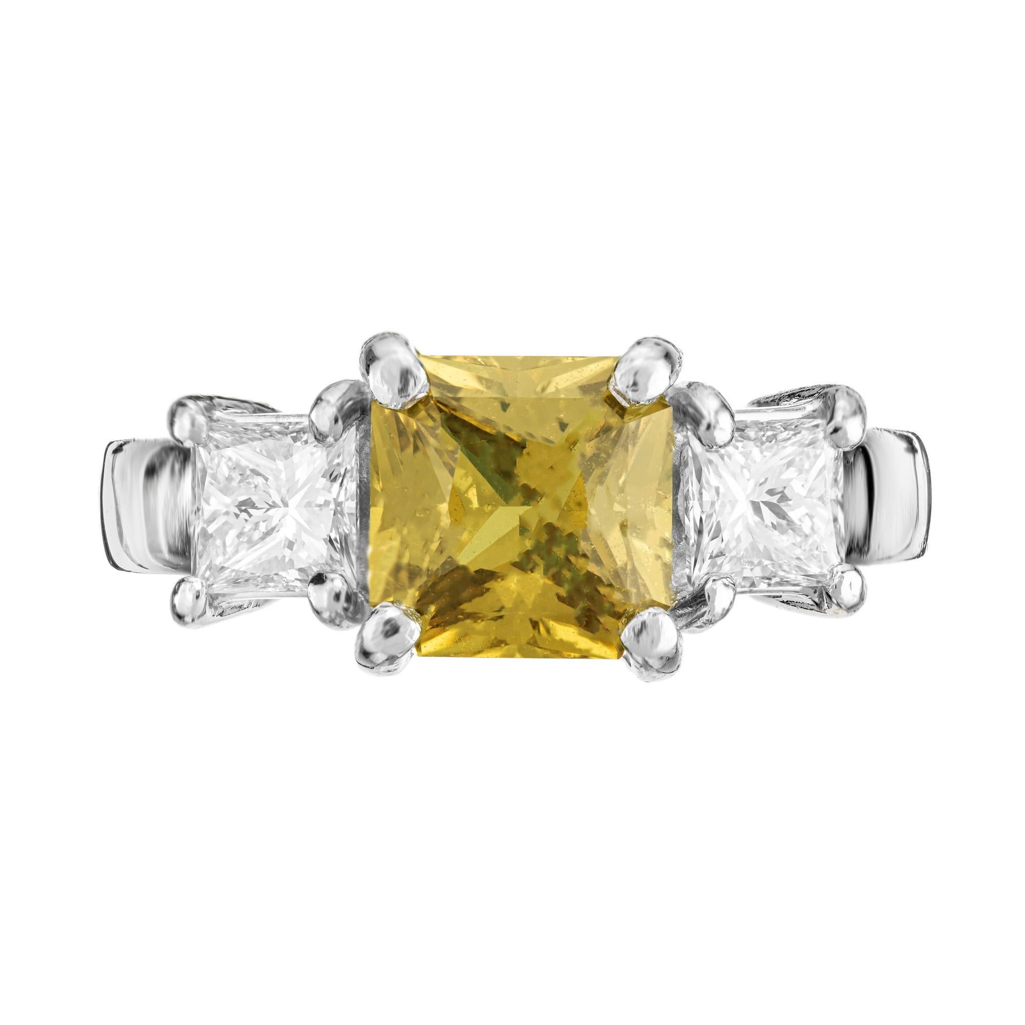 Peter Suchy rich golden yellow sapphire and diamond three-stone engagement ring. 2.32ct yellow sapphire center stone. Mounted in a platinum setting and accented with a princess cut diamond on each side. The GIA has certified this sapphire as