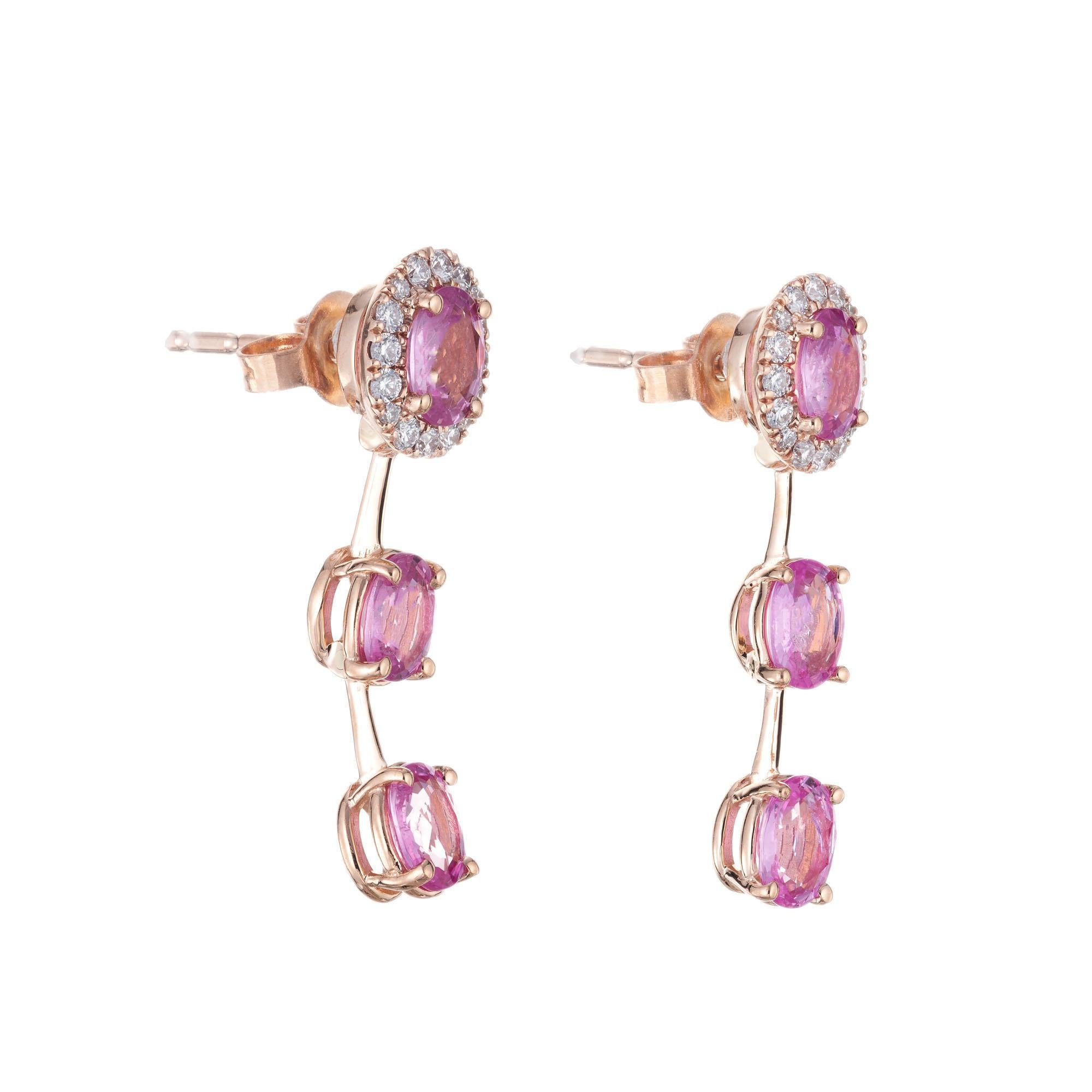 Sapphire and diamond dangle drop earrings. 6 pink oval sapphires with diamond halos around two top sapphires in 14k rose gold. Crafted in the Peter Suchy workshop. GIA certified. one stone randomly tested.

6 oval pink sapphires, SI approx. 2.70cts