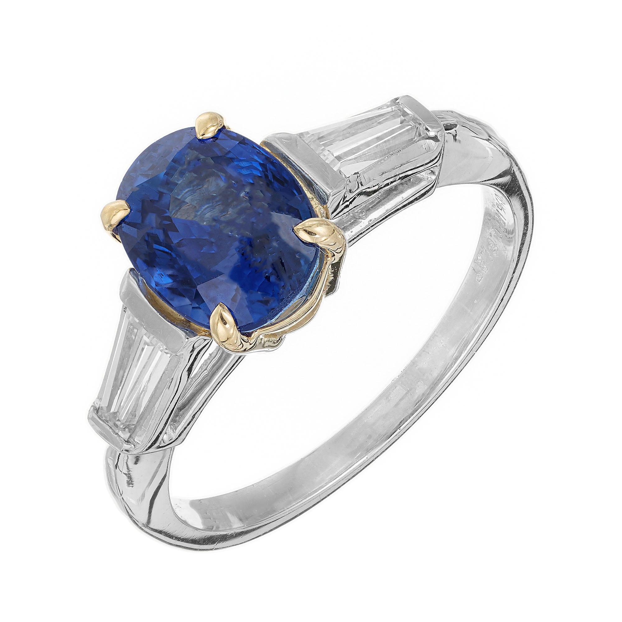 Sapphire and diamond engagement ring. GIA certified center oval sapphire center stone, set in a platinum and 18k yellow gold setting with 2 tapered baguette side diamonds. The sapphire is from a 1930's estate. Created in the Peter Suchy Workshop.