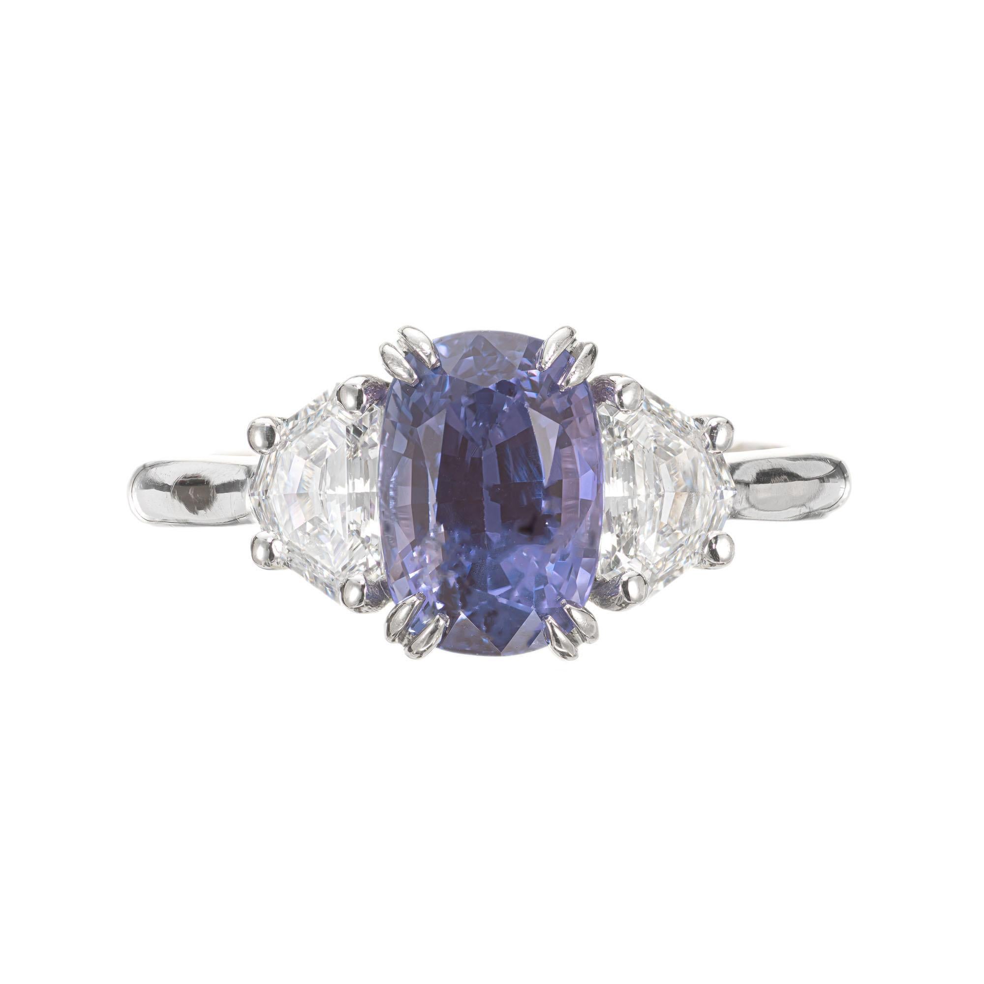 Sapphire and diamond engagement ring. GIA certified purple cushion cut center sapphire, changes color from violet blue to purple in different lights. Set in a platinum three-stone setting with 2 Art Deco step cut shield side diamonds. The sapphire