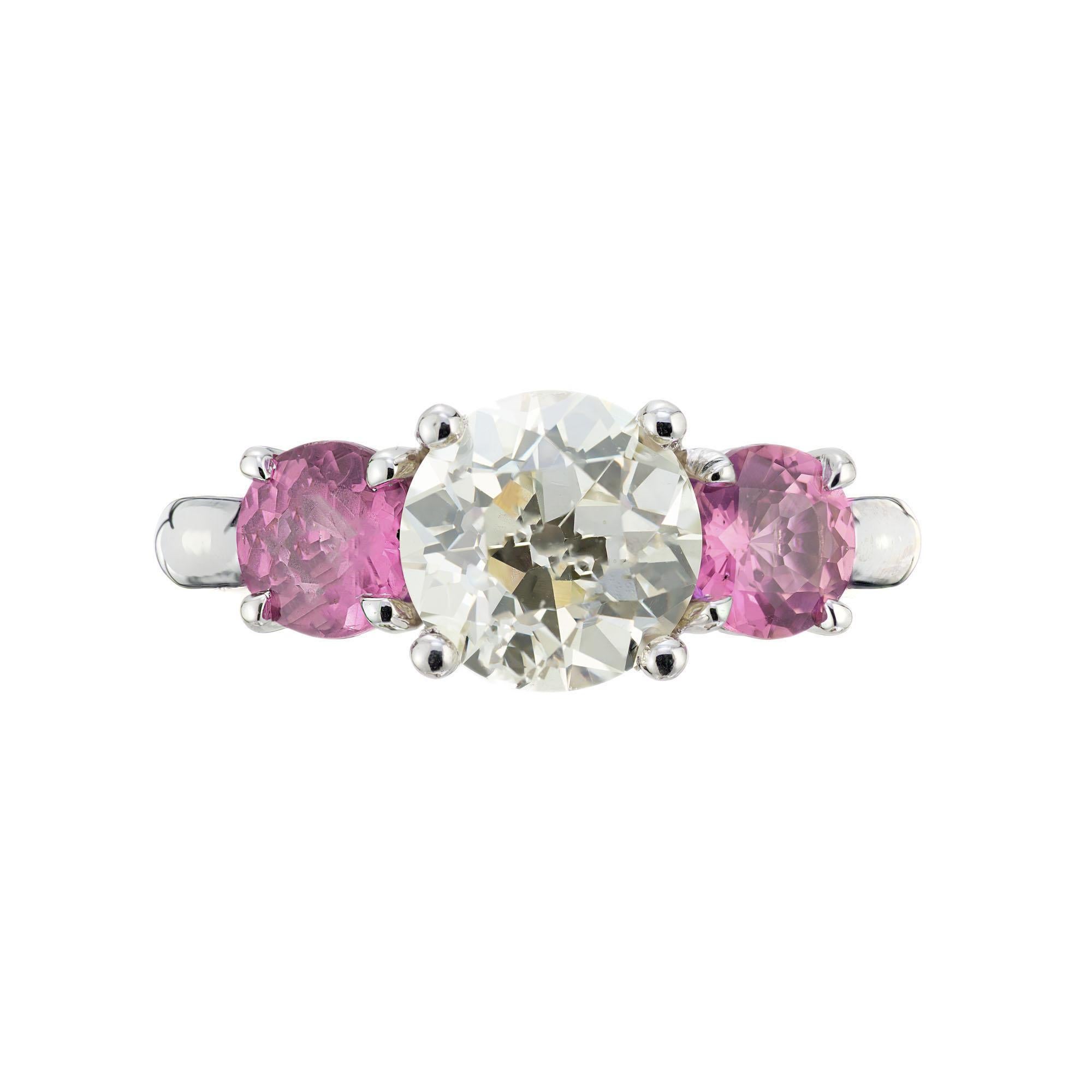 Pink Sapphire and Diamond Platinum three-stone engagement ring. GIA certified Old European cut center Diamond beautifully accented by two natural purplish pink round Sapphires. Set in a platinum mounting made in the Peter Suchy Workshop.

1 Old