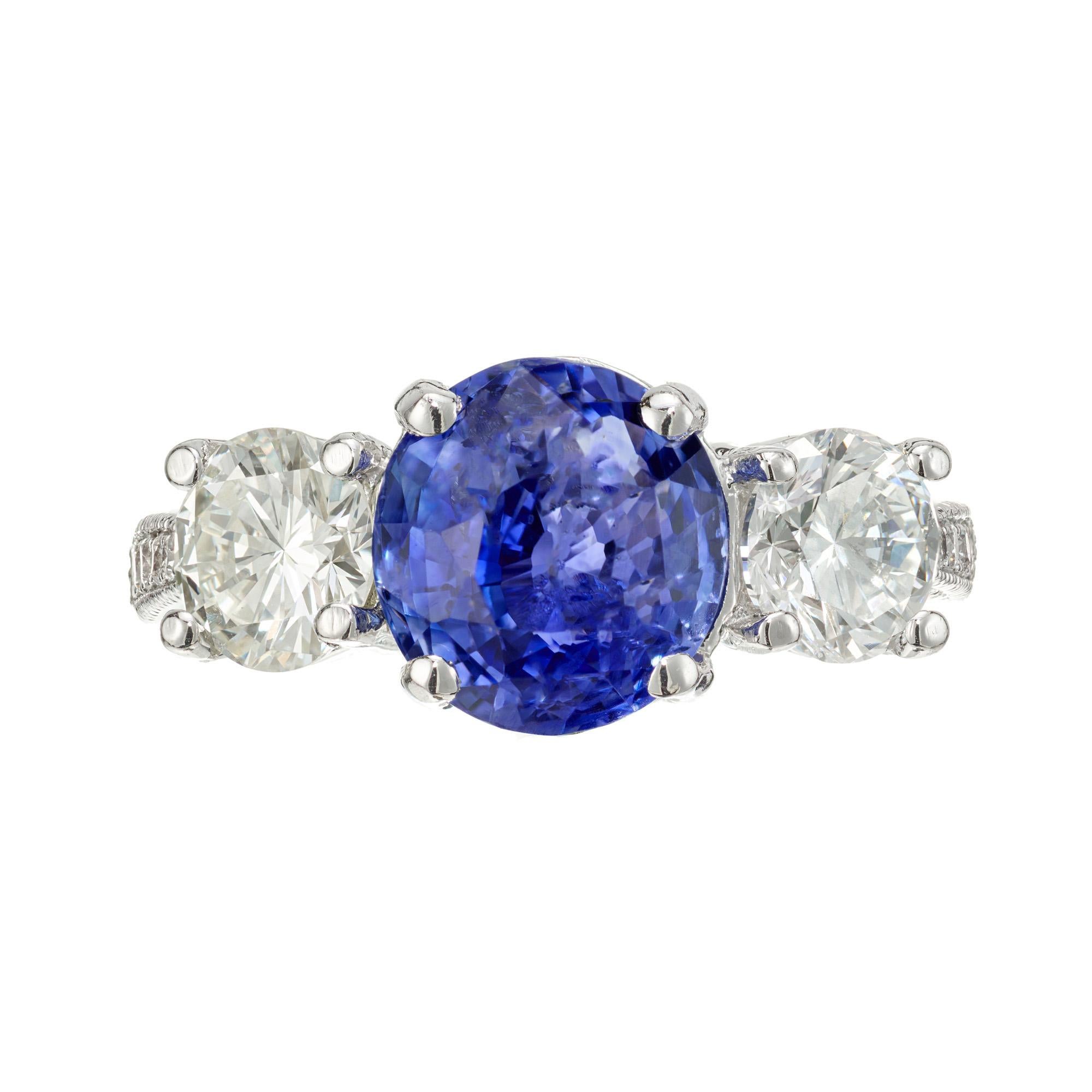 Sapphire and diamond engagement ring. GIA certified Old European cut blue sapphire set in a platinum three-stone setting with two round side diamonds. 10 round diamonds accent diamonds. Certified as Sapphire simple heat only.

1 old European cut