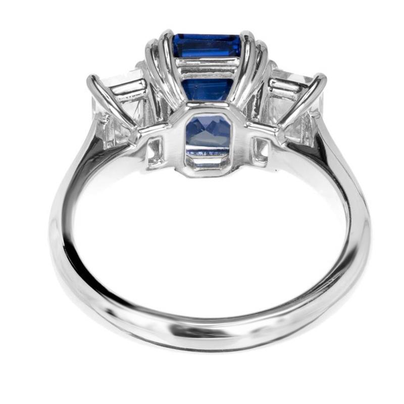 Sapphire and diamond three-stone engagement ring. Exquisite GIA certified octagonal 4.19ct sapphire center stone set in a platinum setting accented with 2 emerald cut diamonds both of which are also GIA certified, near colorless. This step cut