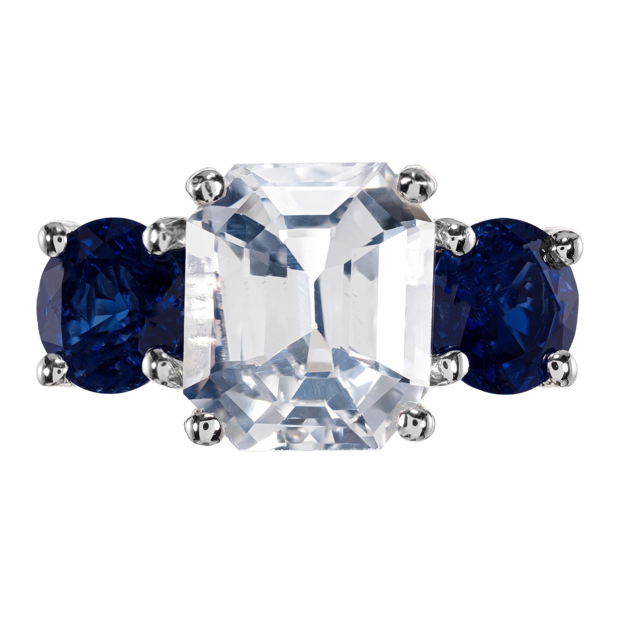 Exceptional sapphire three-stone engagement setting. This ring has a beautiful center octagonal step cut 5.65 carat sapphire that is light blue, GIA certified, natural, and no heat. Accented by two round rich blue brilliant sapphires equaling 2.80