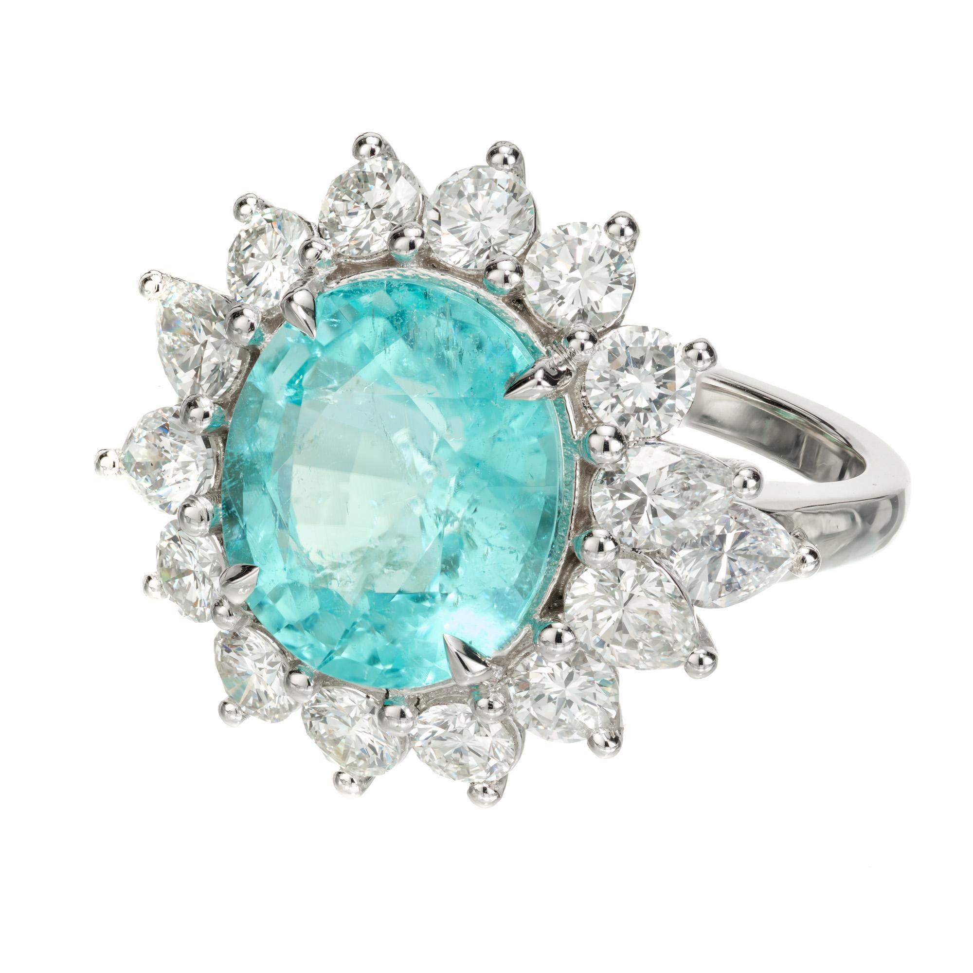 Paraiba diamond cocktail ring. GIA certified oval electric neon bright blue/green Paraiba tourmaline center stone, in a platinum setting with a halo of 10 round brilliant cut diamonds and two 6 pear shaped accent diamonds. This Paraiba has a bright