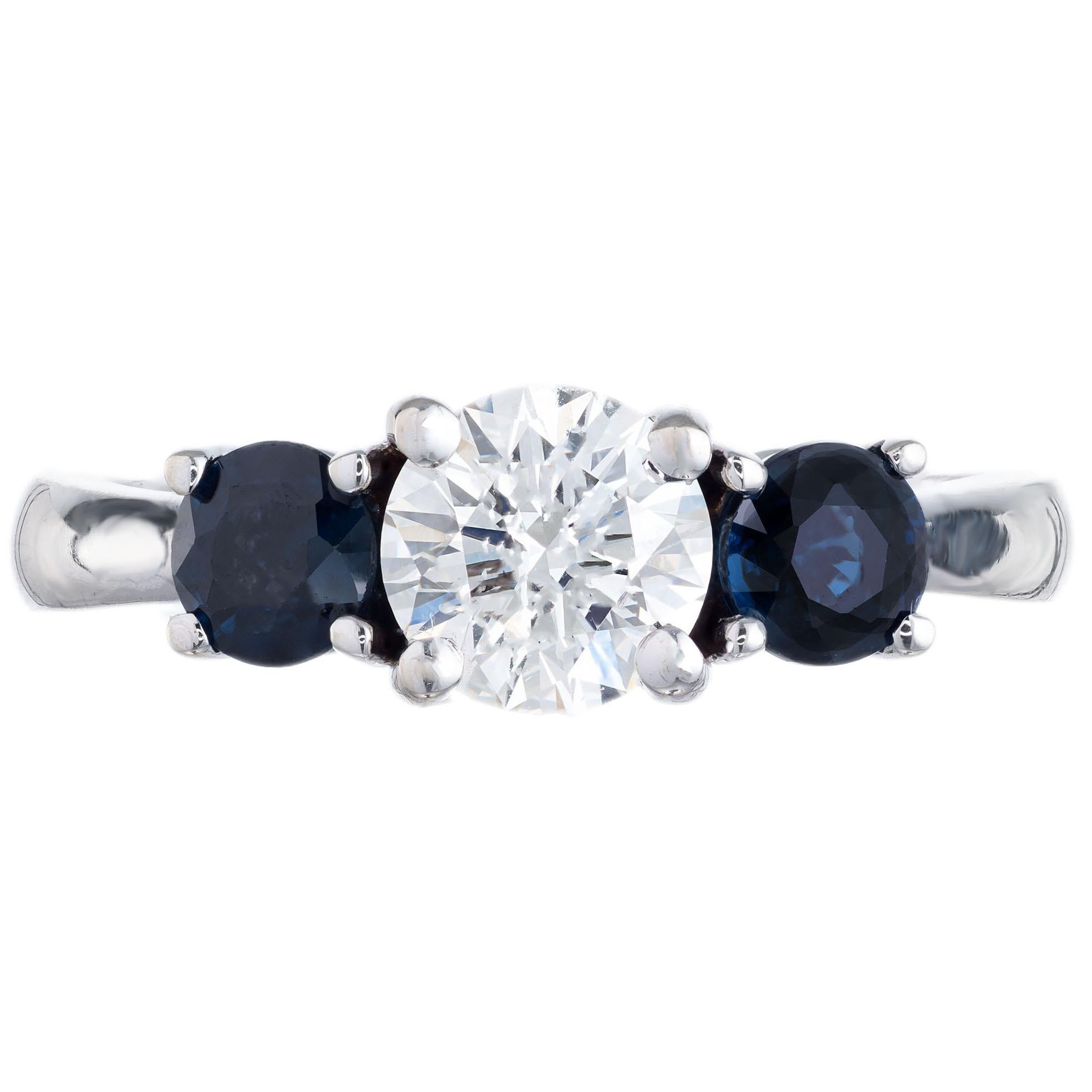 GIA certified center diamond with two round side sapphires in a 14k white gold three-stone setting. Created in the Peter Suchy Workshop. 

1 round Ideal cut diamond approx. total weight .73cts, J, VS2, Table: 56% Depth: 60.9%.  GIA # 213101406
2