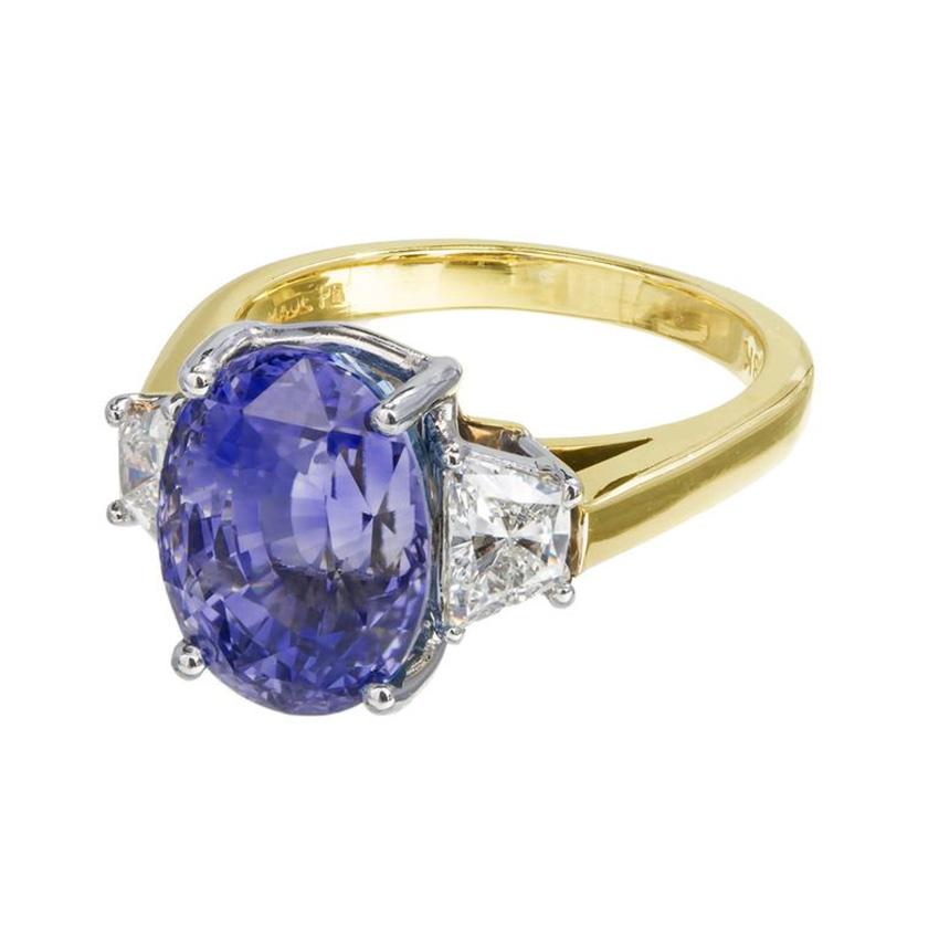 Sapphire and diamond three-stone engagement ring. GIA certified rich purple and blue oval 7.75ct sapphire with a raised crown, small table and step cut bottom, mounted in a crown made out of 18k white gold and a shank of 18k yellow gold. This