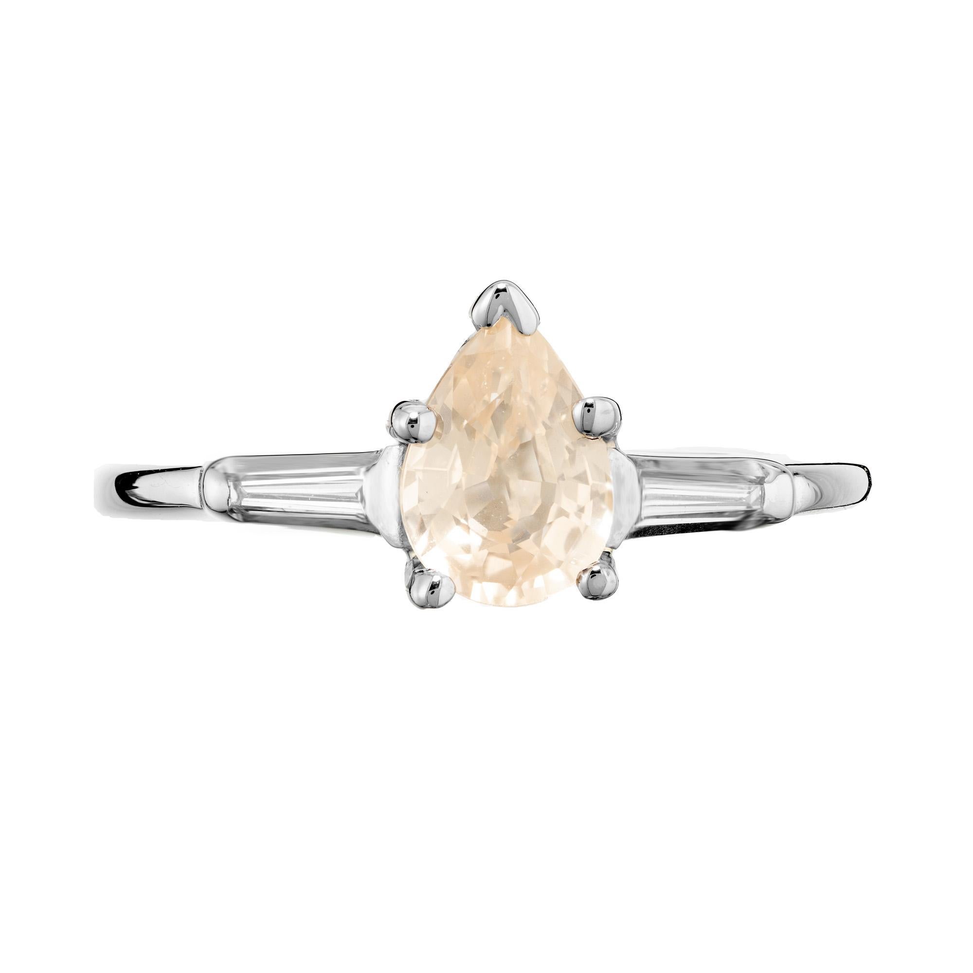 Peach and yellow sapphire and diamond engagement ring. .99cts pear shape sapphire mounted in a 18k white gold setting with tapered baguette diamond on each side. The GIA has certified the sapphire as natural, no heat, with a slightly peach and light