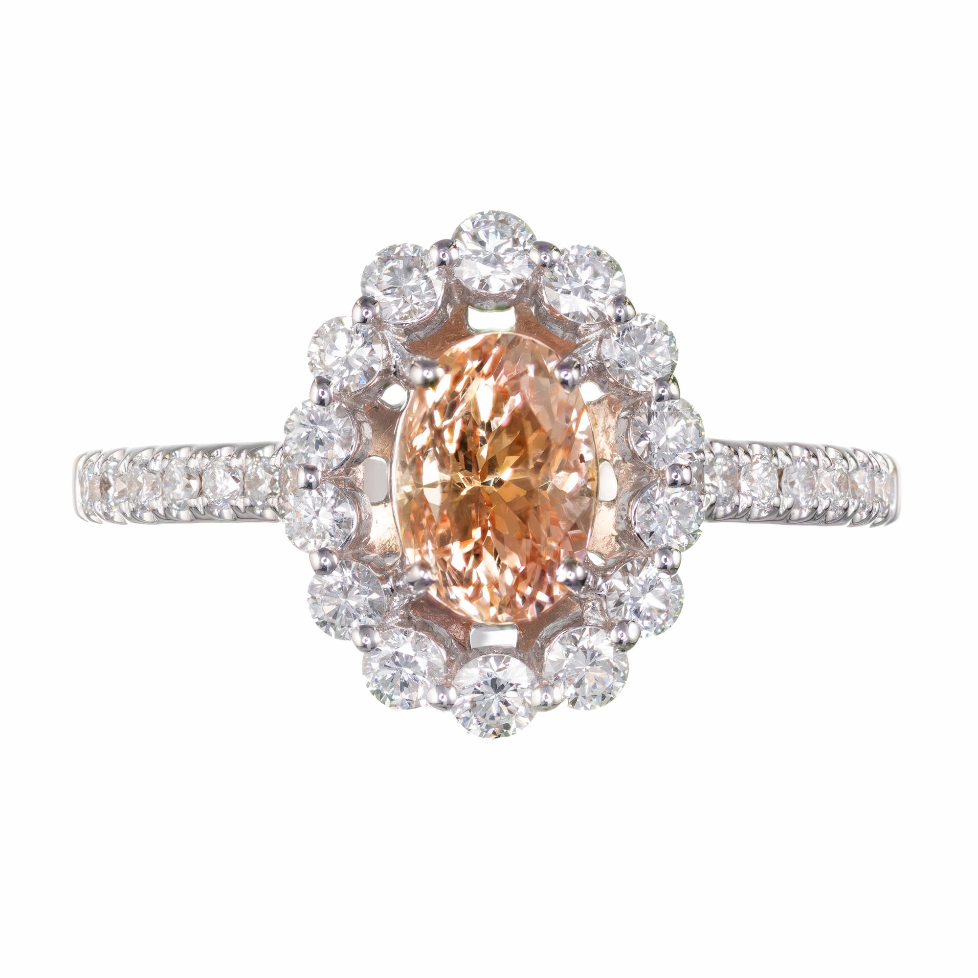 Natural untreated Padparadscha sapphire an diamond engagement ring.  Oval 1.06 carat GIA certified center sapphire with a diamond halo. 18k white gold setting designed and crafted in the Peter Suchy Jewelers Workshop. The sapphire is from an estate