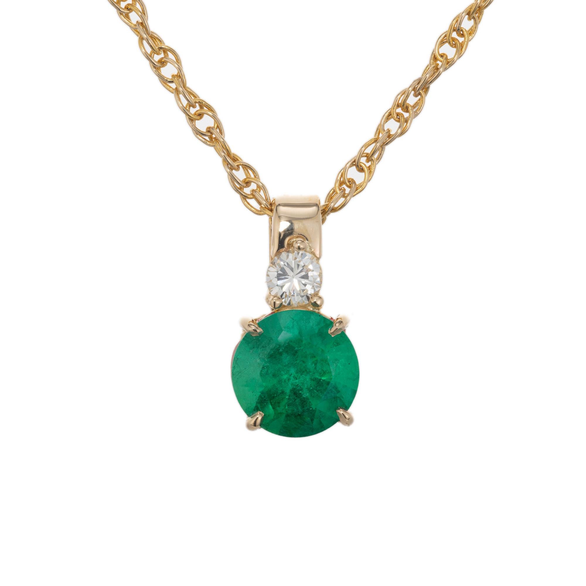 Emerald and diamond pendant necklace. GIA certified 1.08 carat round emerald set in a 14k yellow gold four prong setting, accented with a round cut diamond set atop the emerald on the bail. GIA has certified it as natural with F1  minor heating.