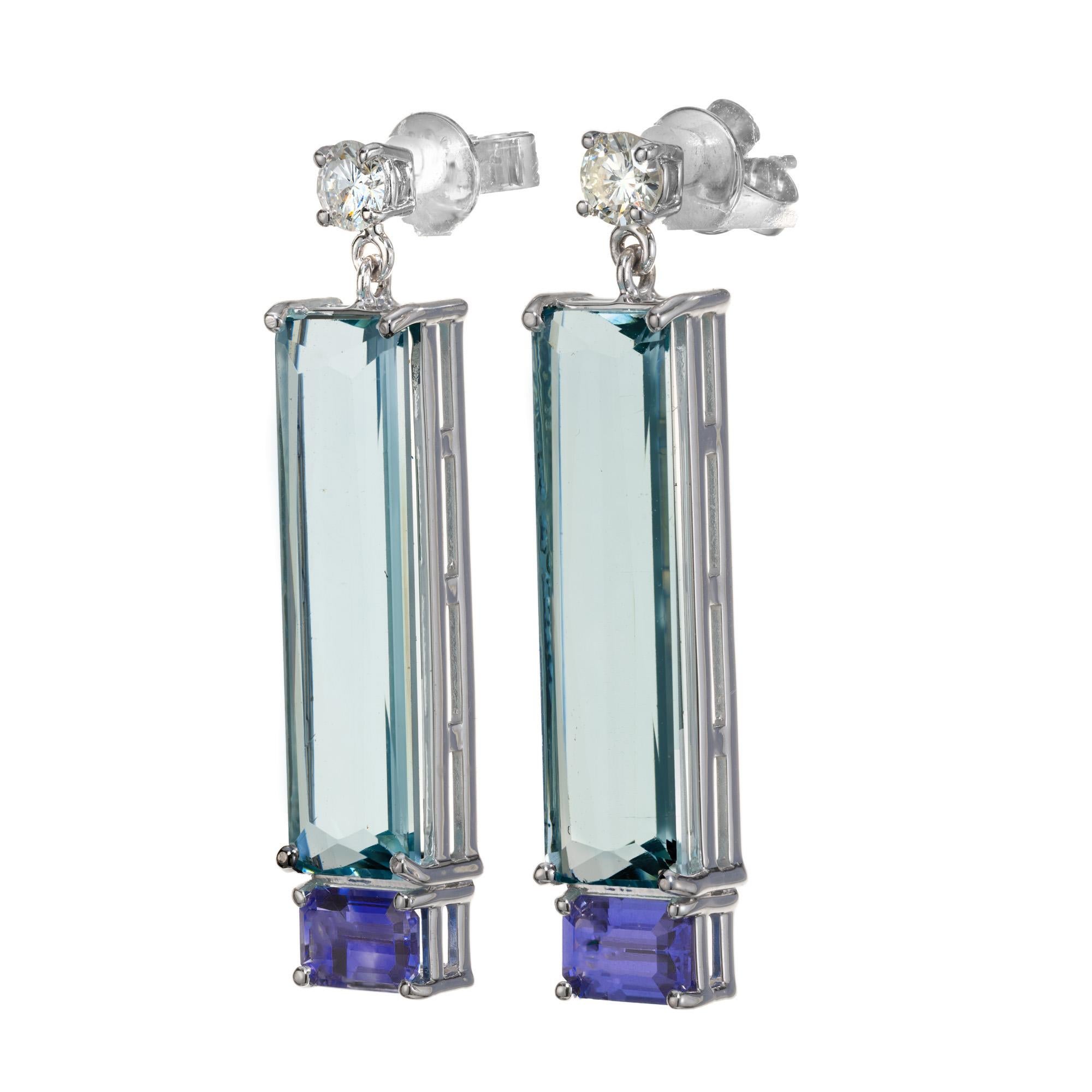 Aquamarine, sapphire and diamond dangle earrings. Two unusual elongated emerald cut natural aquas totaling 9.73cts. matched with blue and purple emerald cut accent sapphires, set in 14k white gold settings. One round brilliant cut diamond tops off