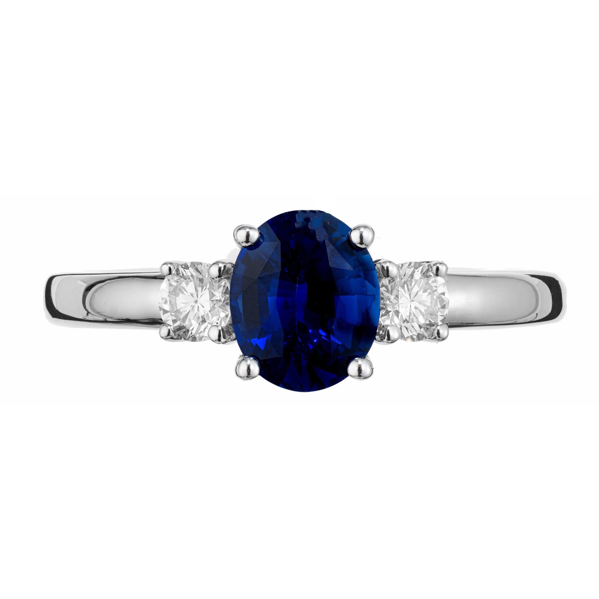 Peter Suchy GIA Certified Sapphire Diamond White Gold Engagement Ring. Oval 1.24 carat center sapphire mounted in a 14k white gold three-stone setting with 2 round brilliant cut side diamonds. The sapphire is a deep rich blue hue which is enhanced