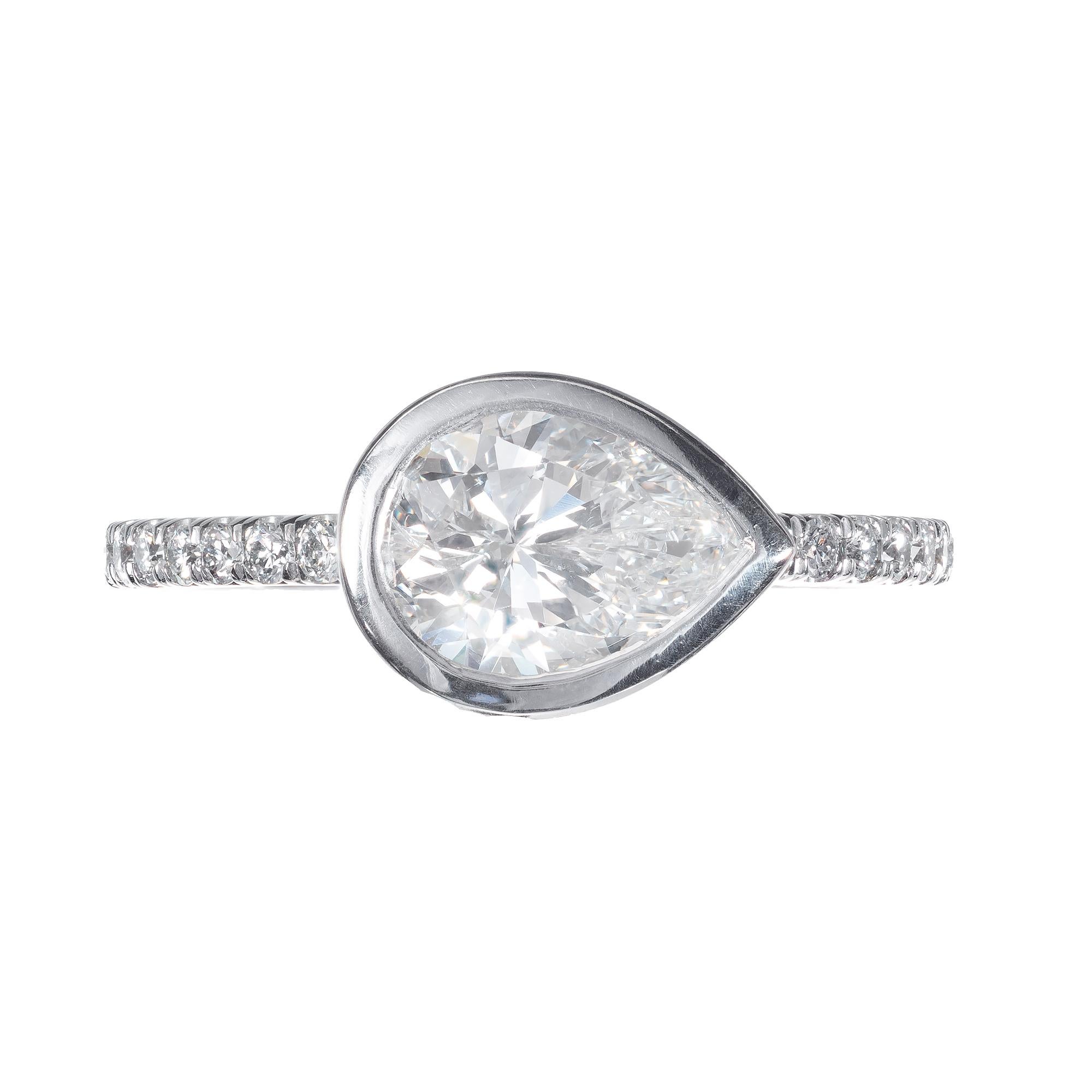 Pear shaped diamond engagement ring. Bezel side set pear shaped center stone in a platinum setting with round accent diamonds, from the Peter Suchy Workshop.

1 pear shaped F SI2 diamond, Approximate 1.27cts GIA Certificate #5181226671
16 round