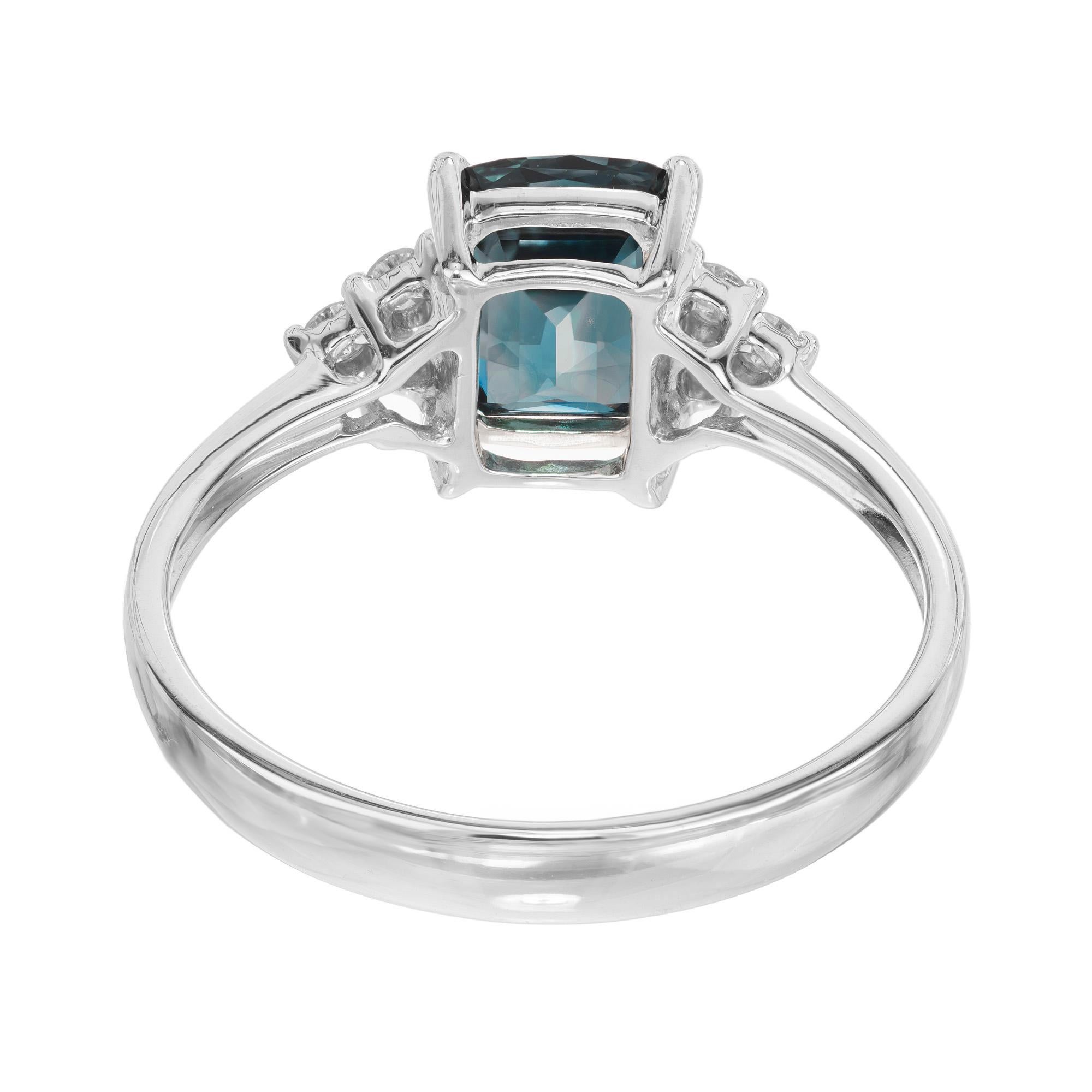 Dieser atemberaubende Ring ist mit einem grünen blauen Saphir im Kissenschliff von 1,30 Karat besetzt, der das Licht mit unvergleichlicher Brillanz einfängt. Um den Saphir herum sind 6 runde Diamanten im Brillantschliff in einer Fassung aus 18 Karat